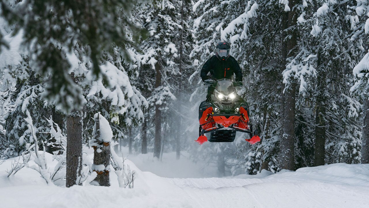 2026 Lynx Brutal RE snowmobile leaping over a bump on the trail.