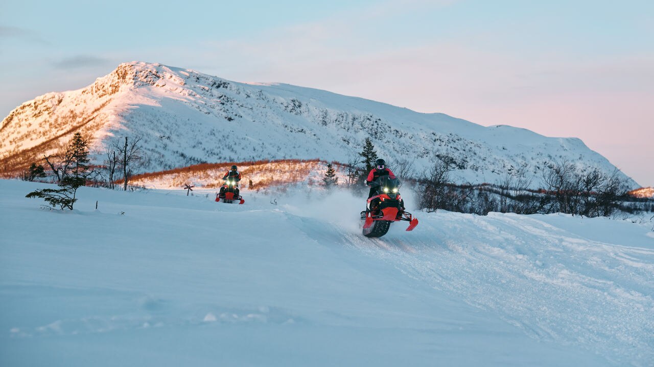 Two 2027 Lynx Rave RE snowmobile racing at high speed