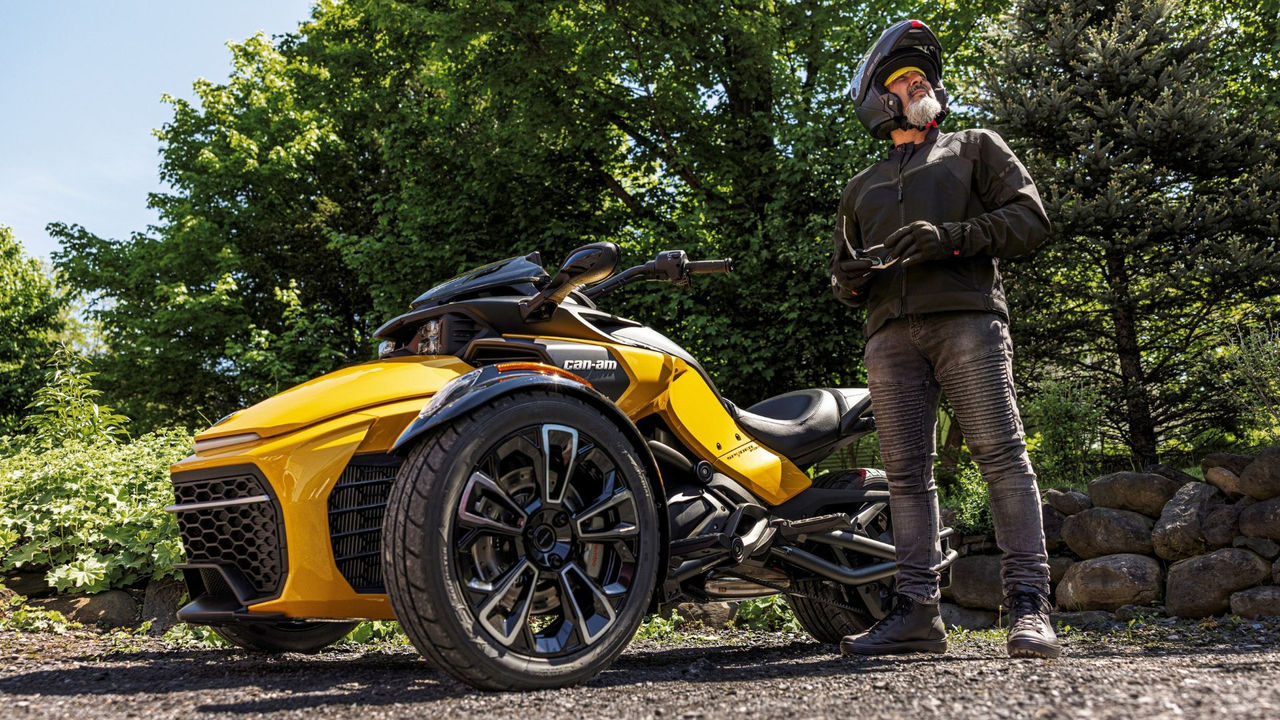 A rider standing next to a 2026 Can-Am Spyder F3 3-wheel motorcycle