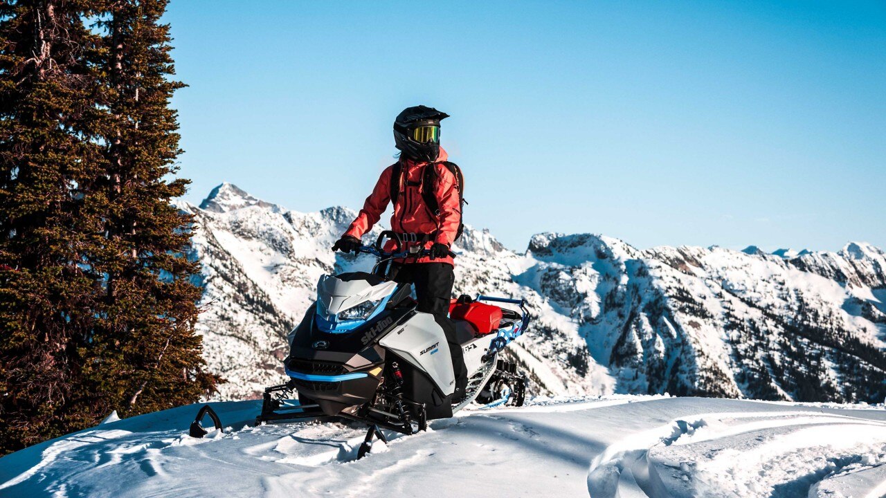 Woman on her Ski-Doo Summit Edge on the top of a mountain