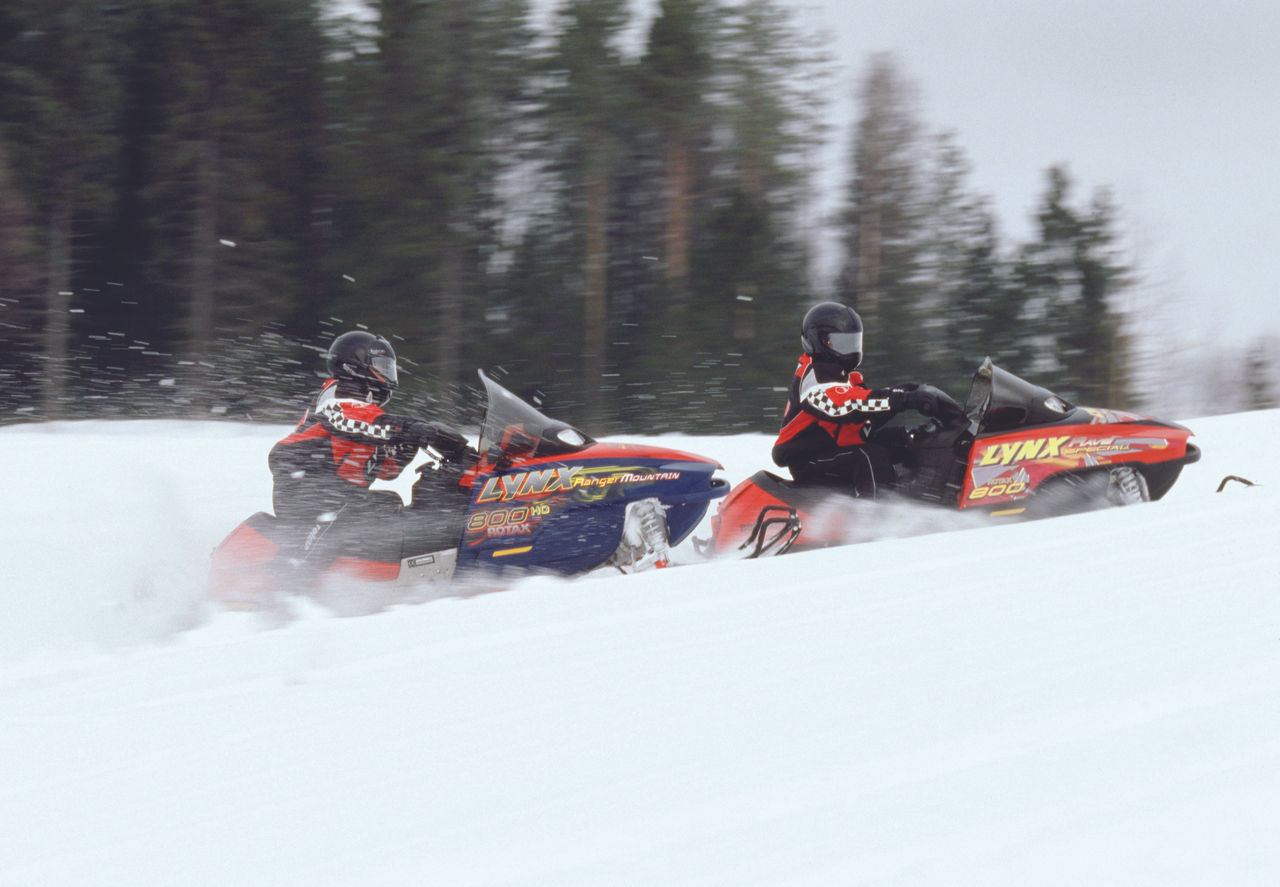Lynx Rave and Ranger Mountain snowmobiles accelerating uphill