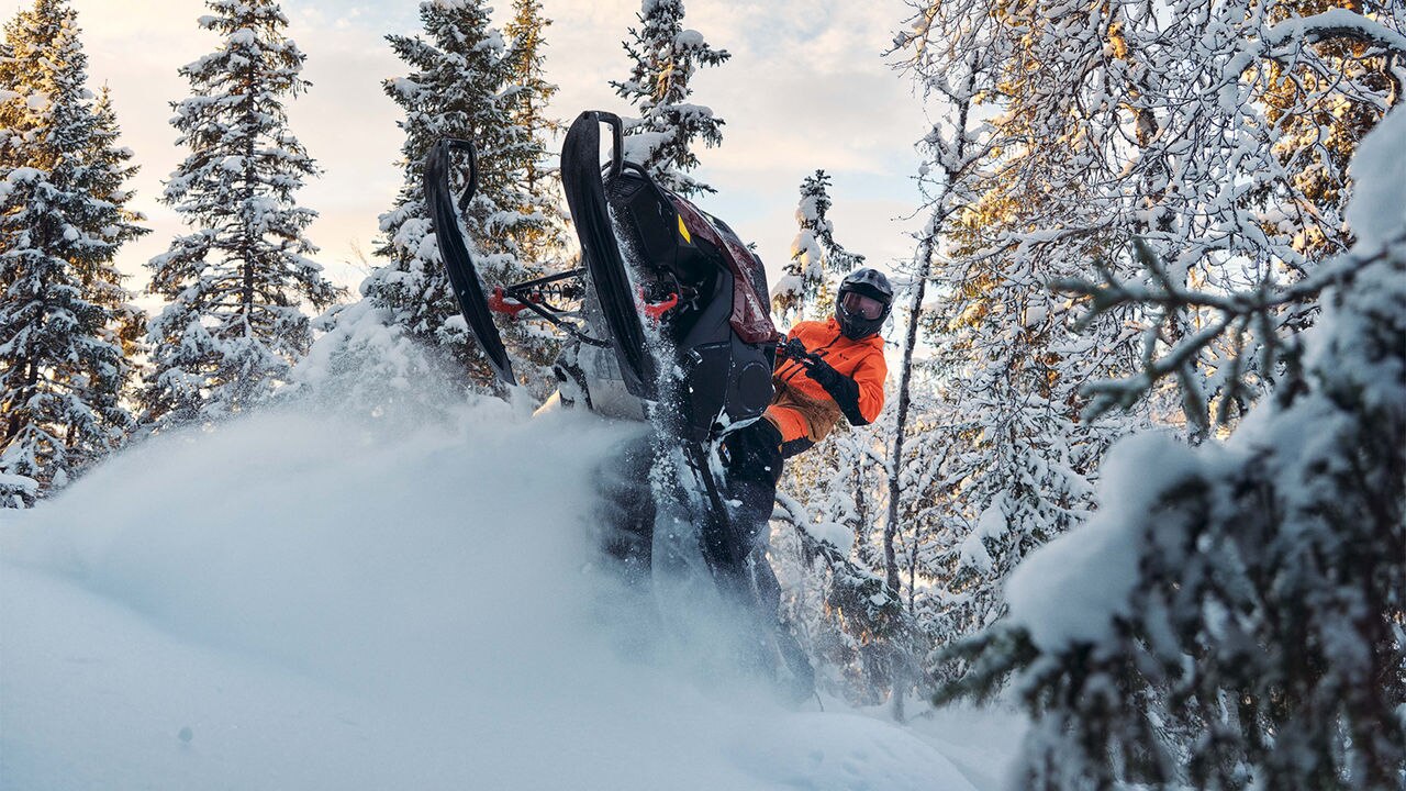 Lynx Shredder DS 2025 snowmobile wheelying in deep snow in forest