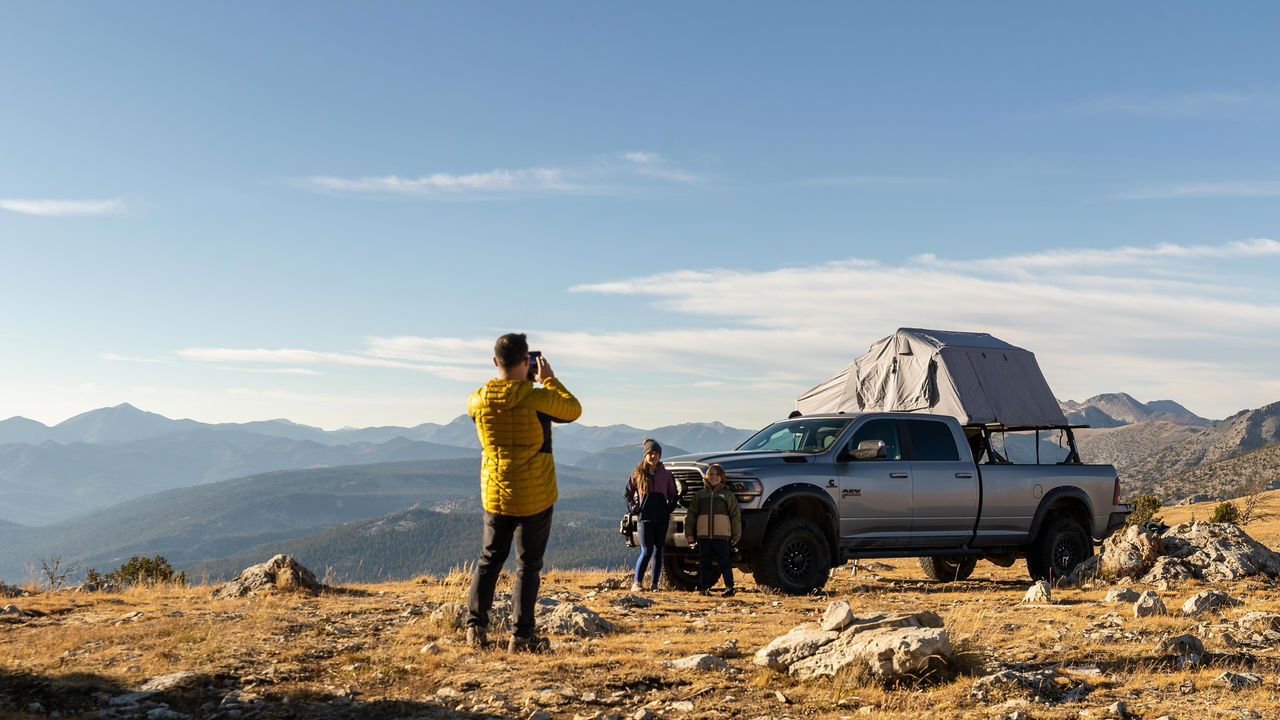 Tony Jenkins taking his two kids in photo at the top of a mountain