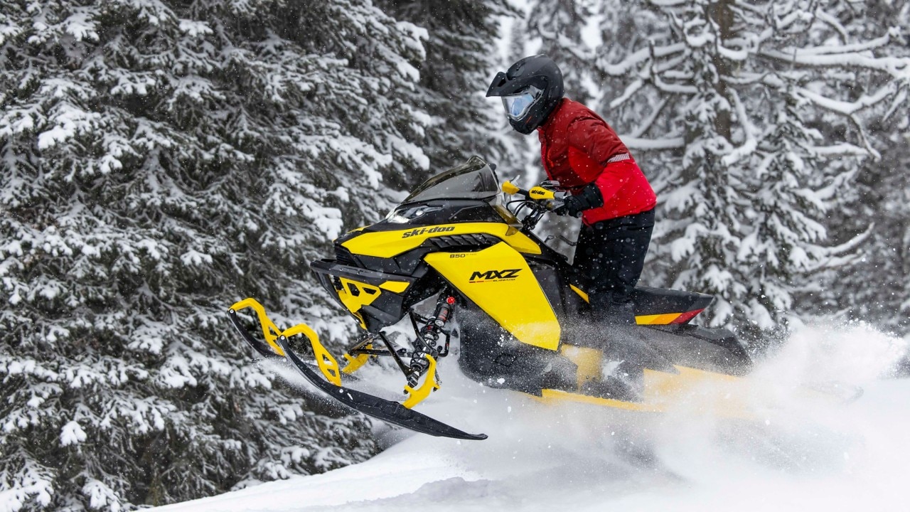 Woman jumping with his 2023 Ski-Doo MXZ