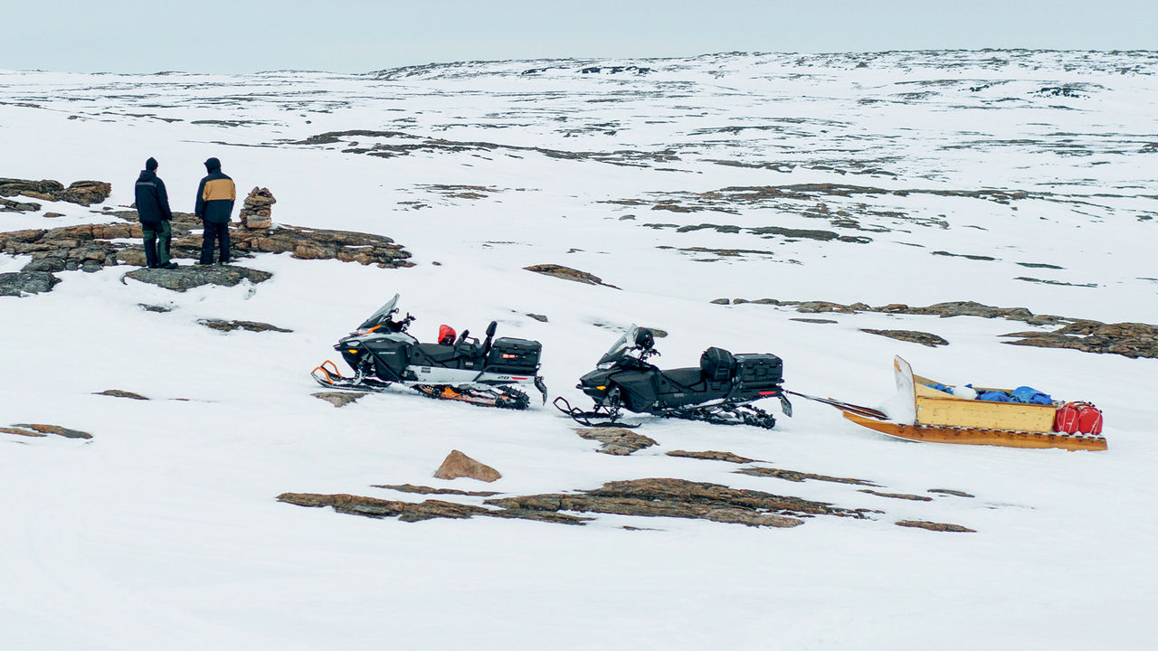 Dvaja muži stoja vedľa ich Ski-Doo skútrov v Nunavute