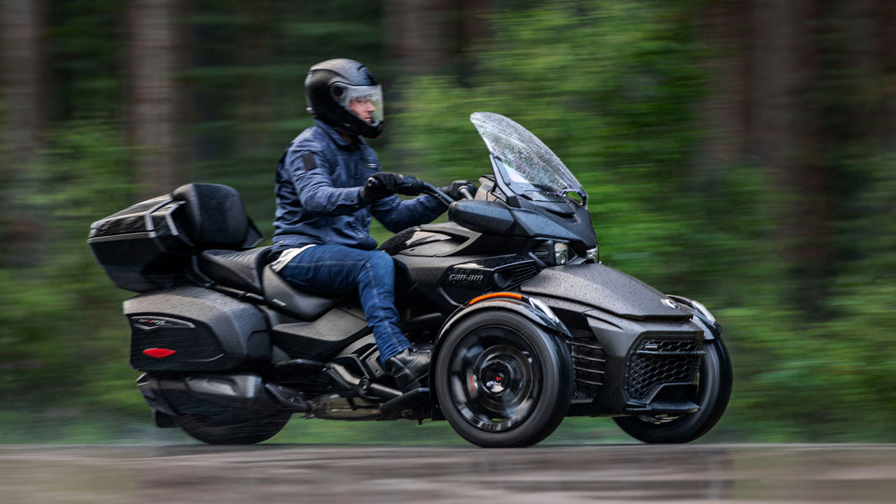 Voznik upravlja predelano trikolesno vozilo Can-Am Spyder F3.