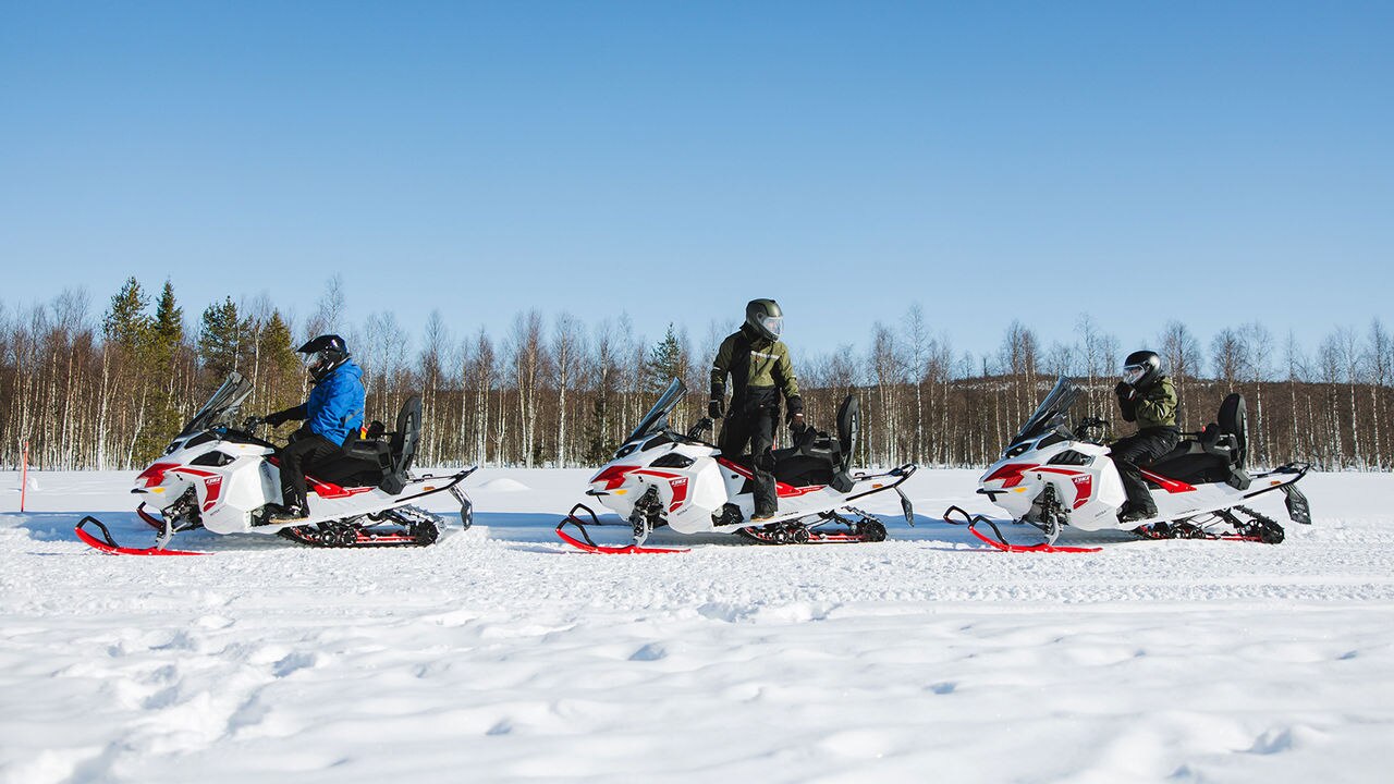Tri električne motorne sani Lynx Adventure, parkirane na stezi