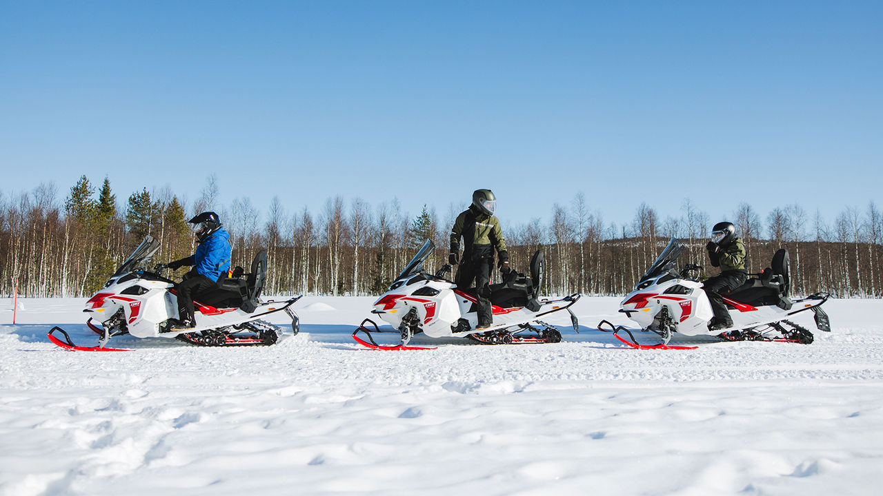 Three Lynx Adventure Electric snowmobiles parked on trail