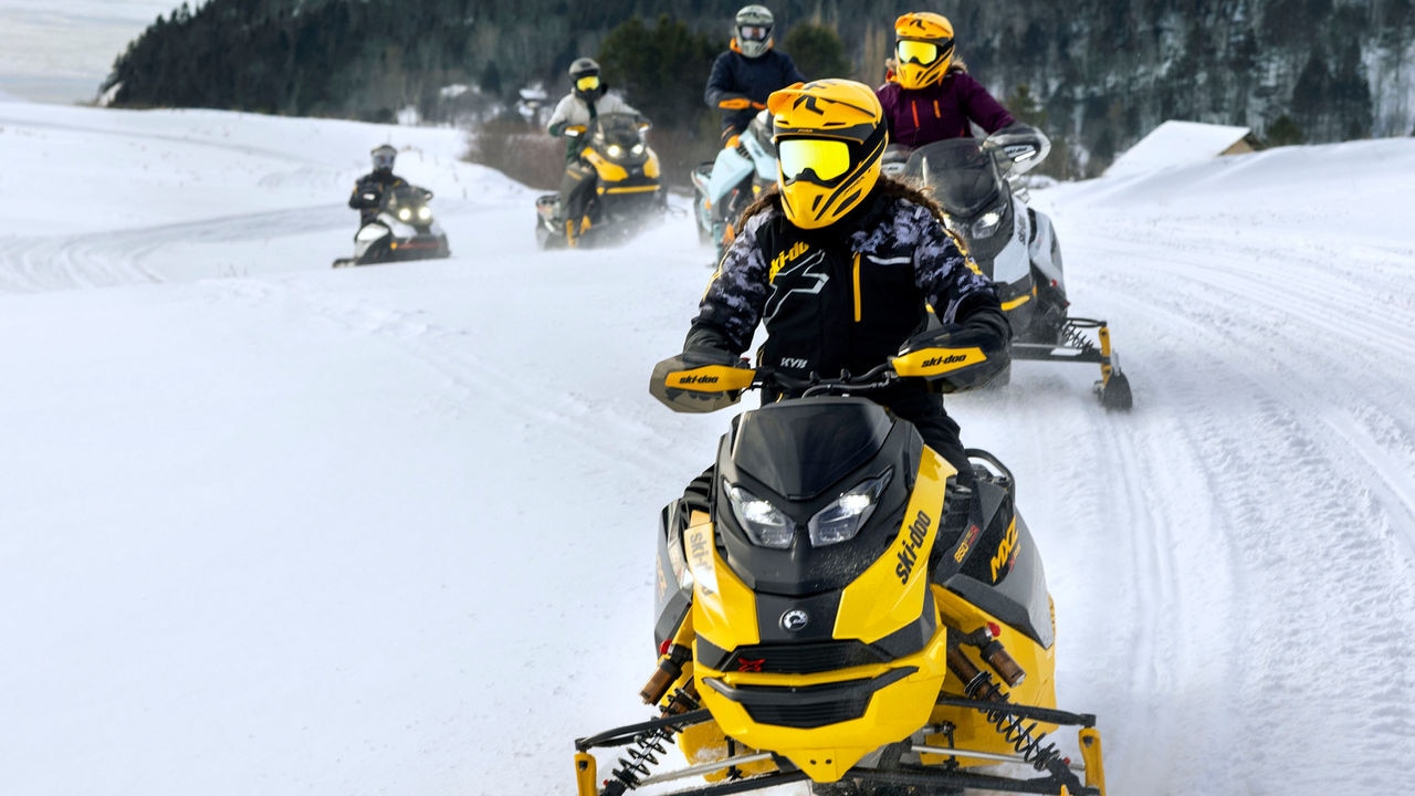 Nje burre duke ngasur një motor te bores Ski-Doo