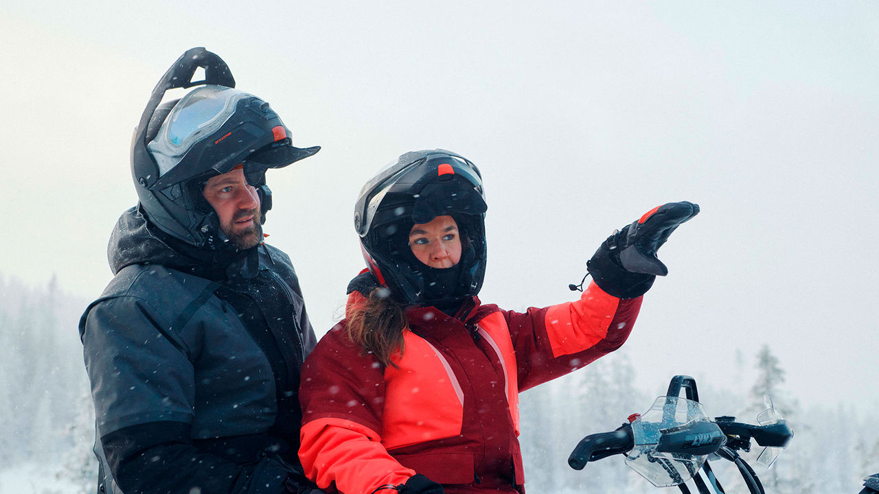 Çifti i veshur me xhaketa Lynx Stamina Arctic në makinë dëbore