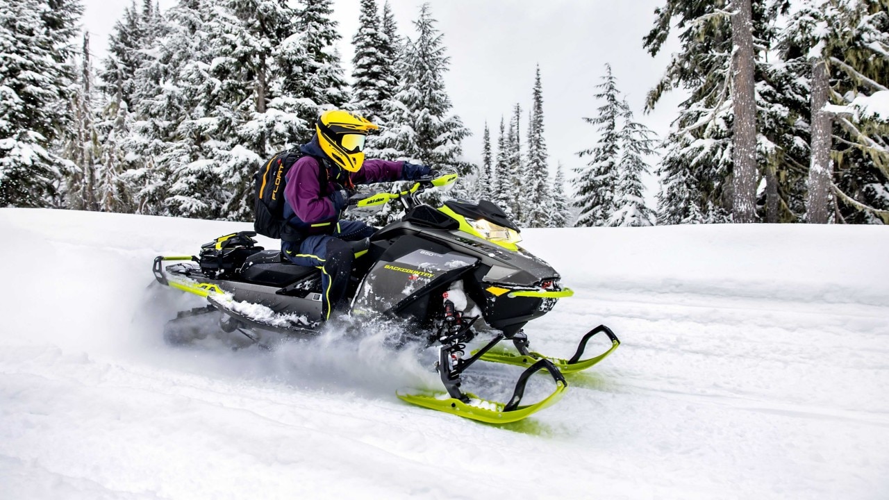 Woman snowmobiling on a trail with her 2023 Ski-Doo Backcountry