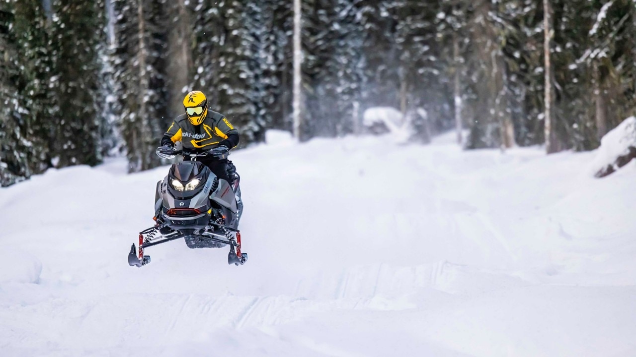 Man snowmobiling on a snowmobile trail with the 2023 Ski-Doo Renegade