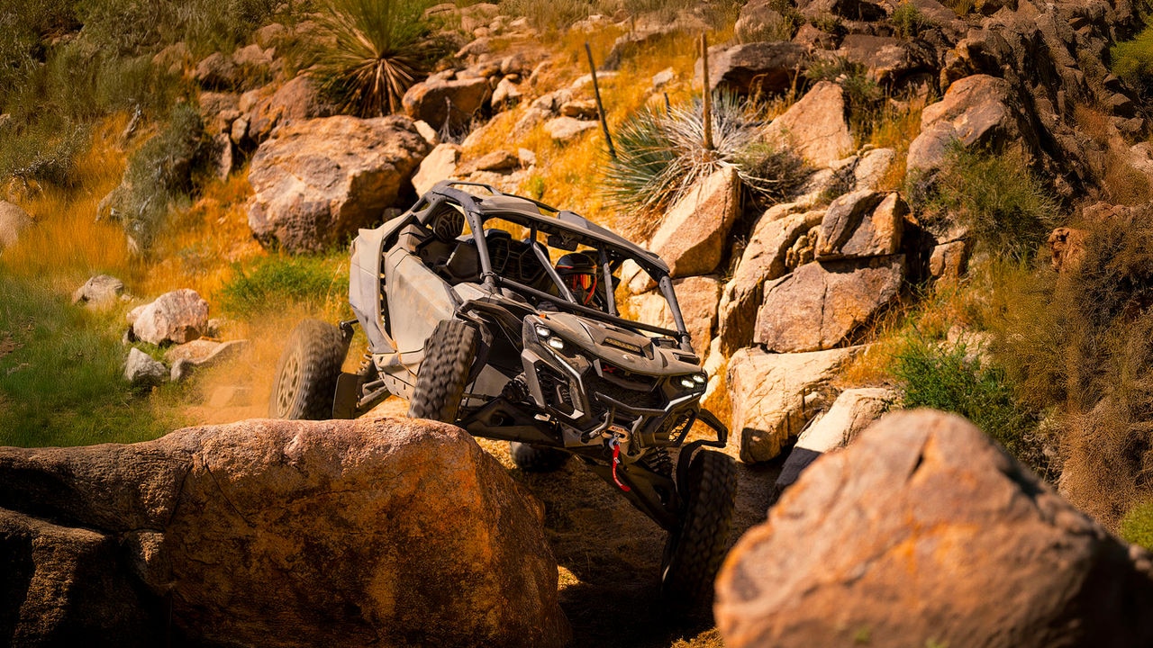 A Can-Am Maverick X3 Max X RC climbing over rocks