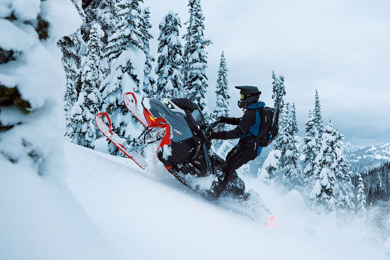 2027 Lynx Shredder DS riding up a snowy mountain