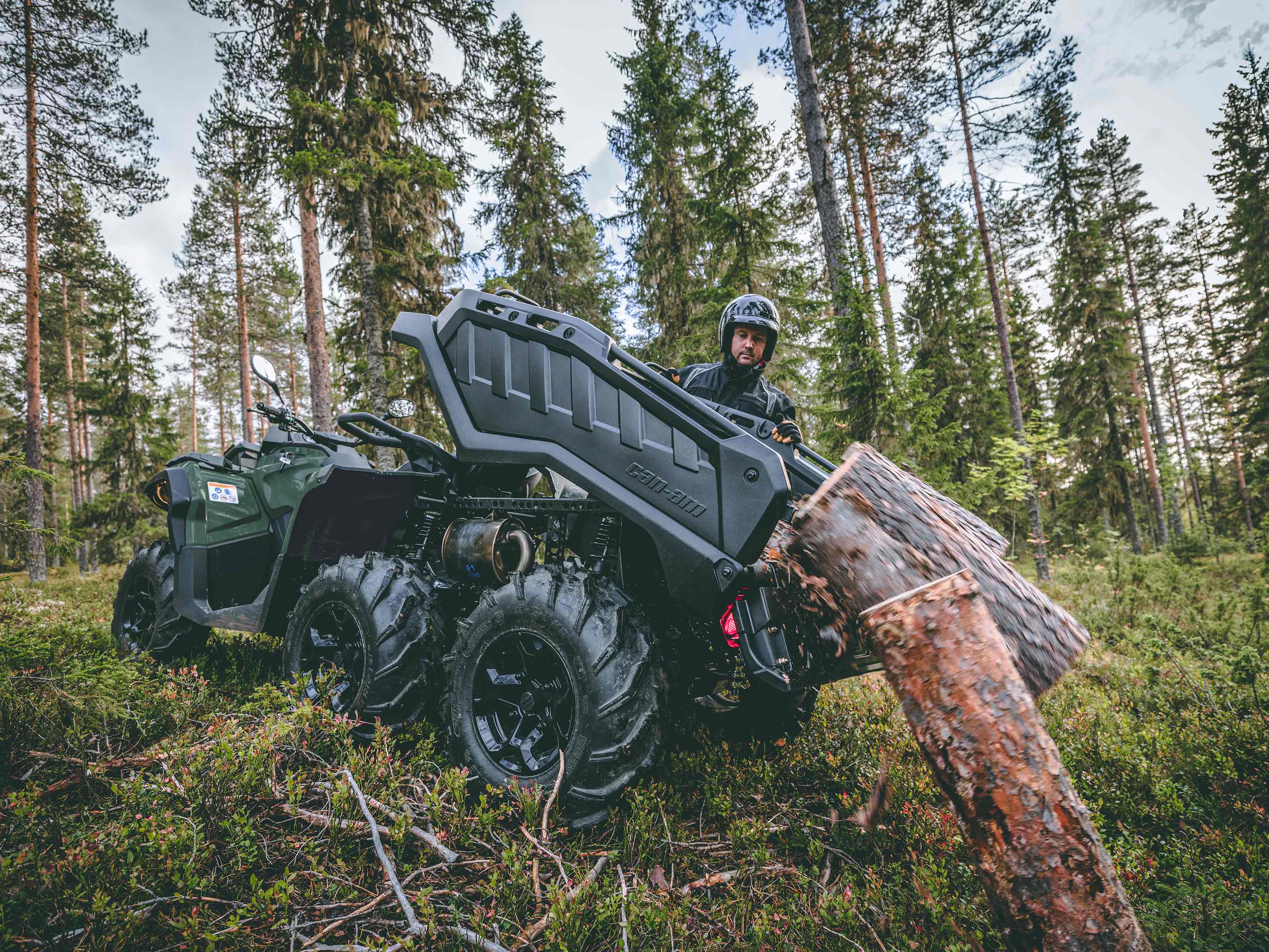 A Can-Am Outlander PRO XU holding a chainsaw in the dedicated slot, equipped with a LinQ Jerry can and bumpers