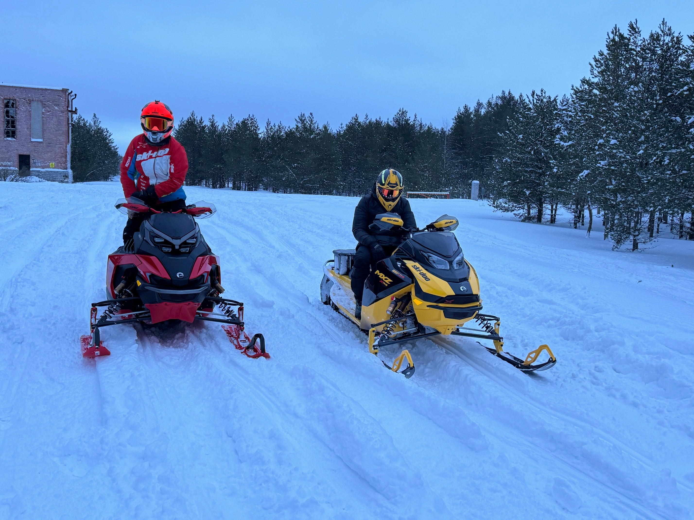 Two guys sitting on 2024 Snowmobiles