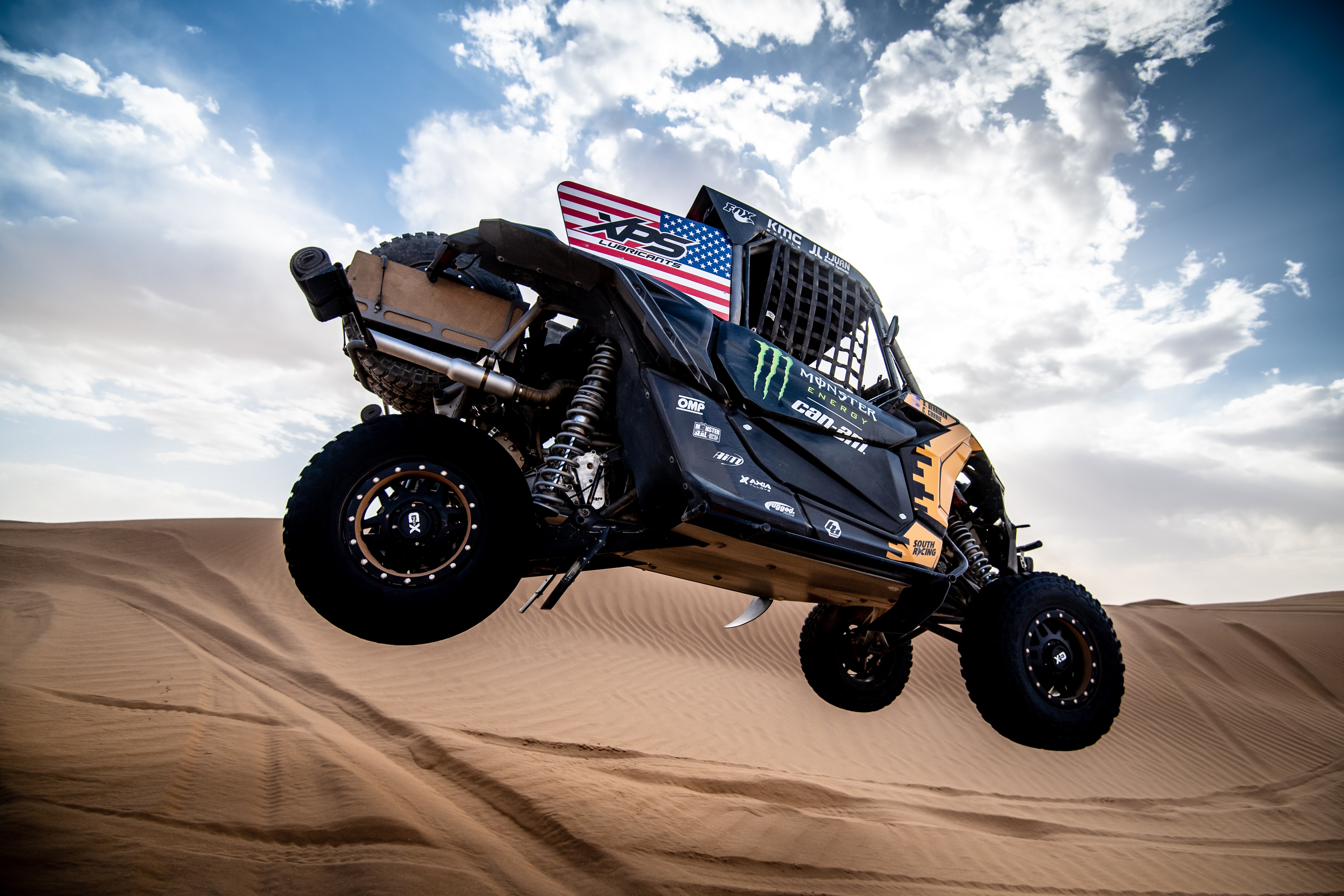 Man driving a Maverick X3 in desert dunes