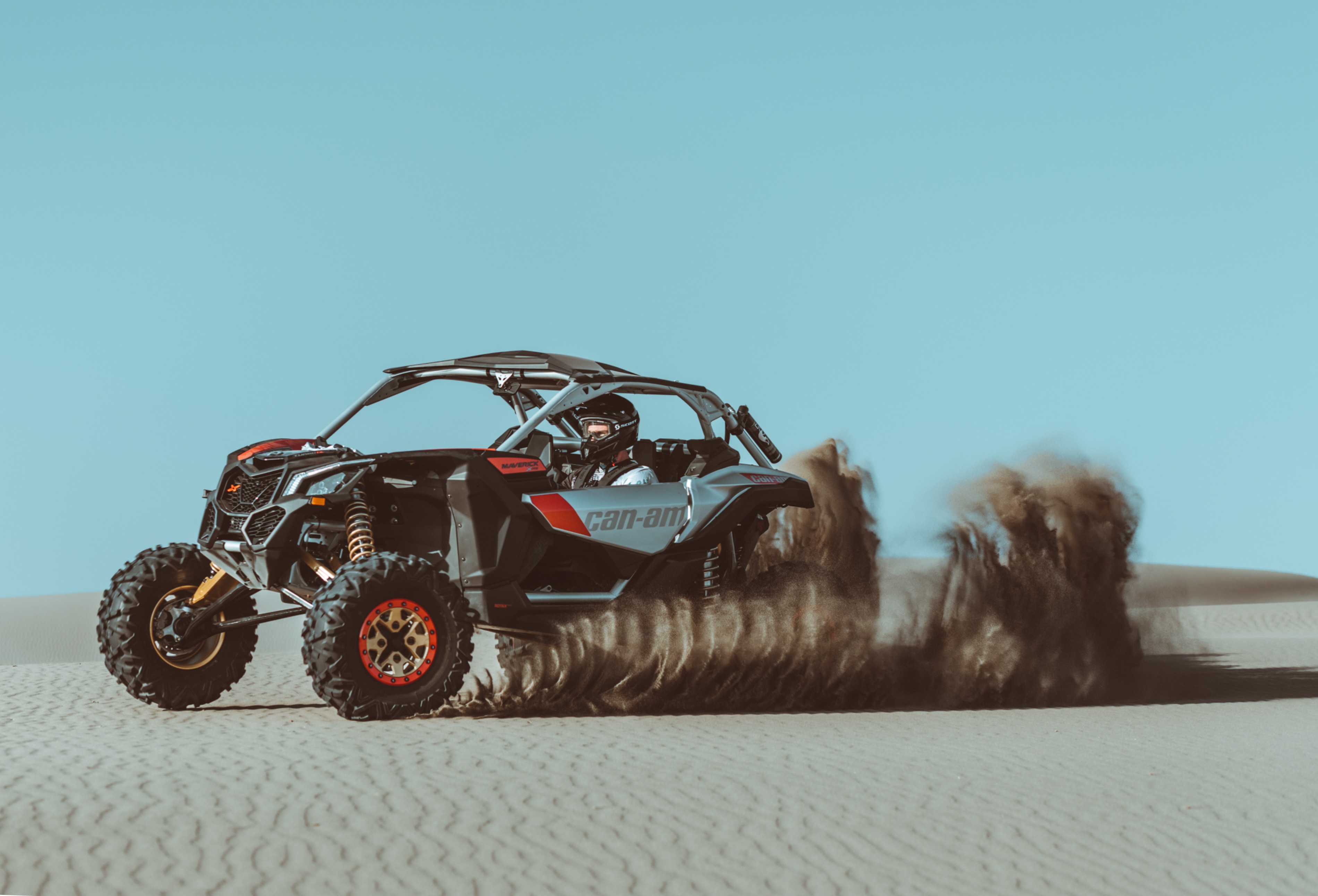 Man driving a Can-Am Maverick in the sand