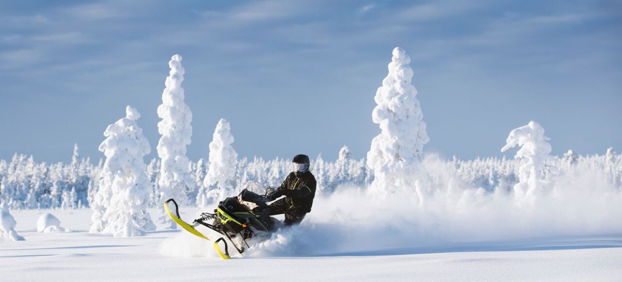 Muž jedoucí na sněžném skútru Lynx