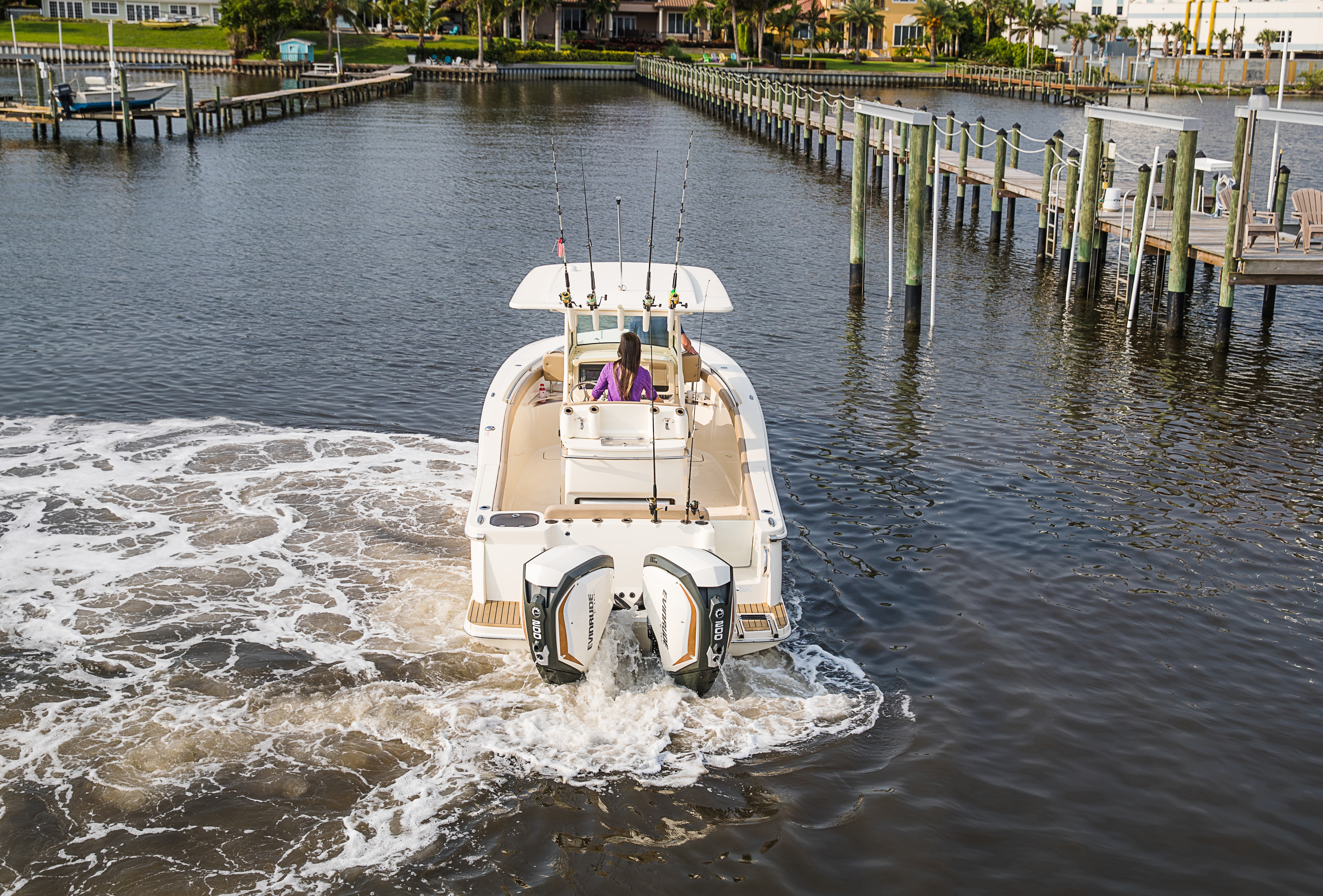 Woman driving a boat yielding Evinrude motors