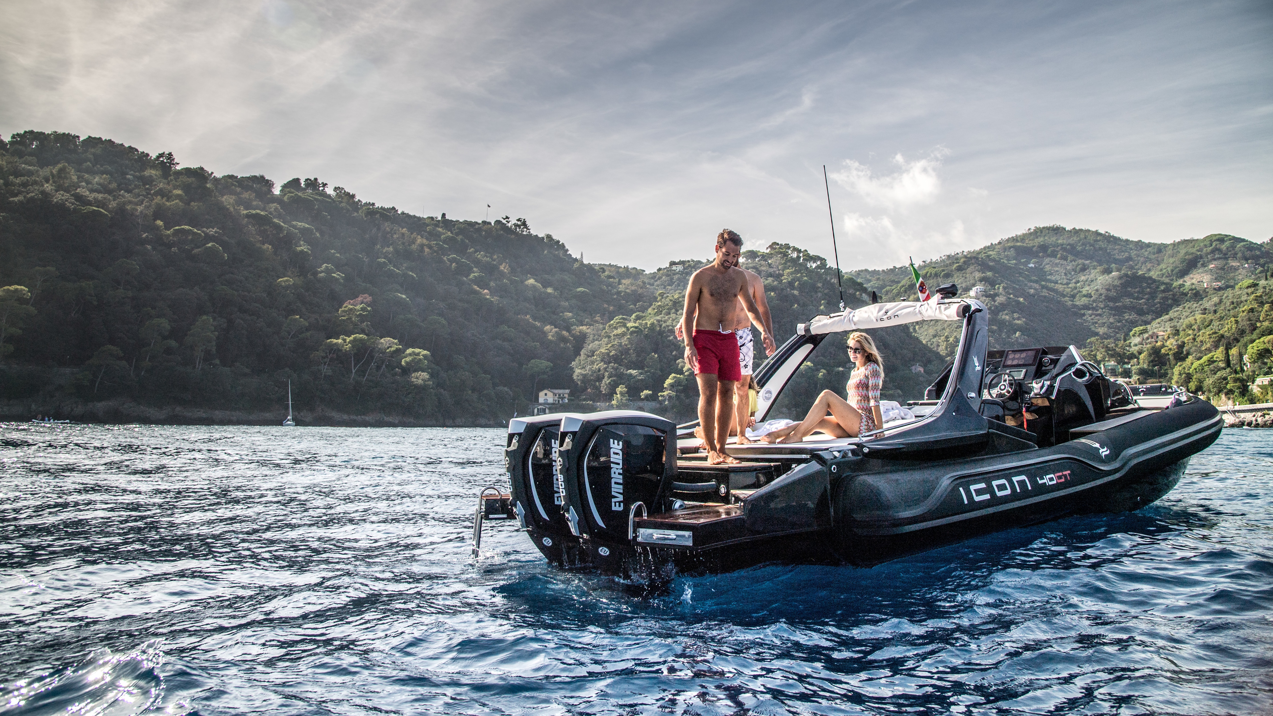 Three friends on a boat yielding Evinrude motors