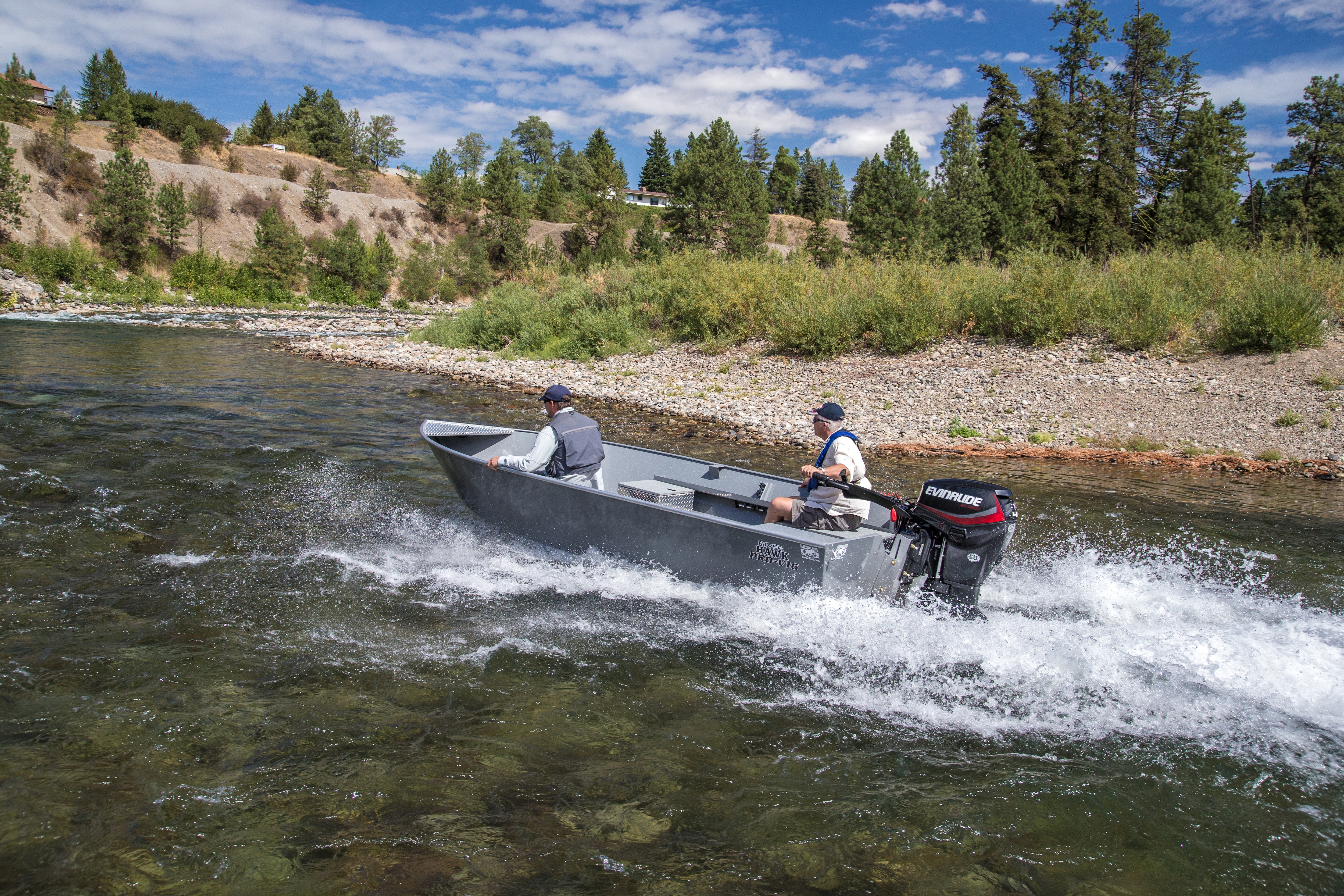 Two men driving a boat in shallow water