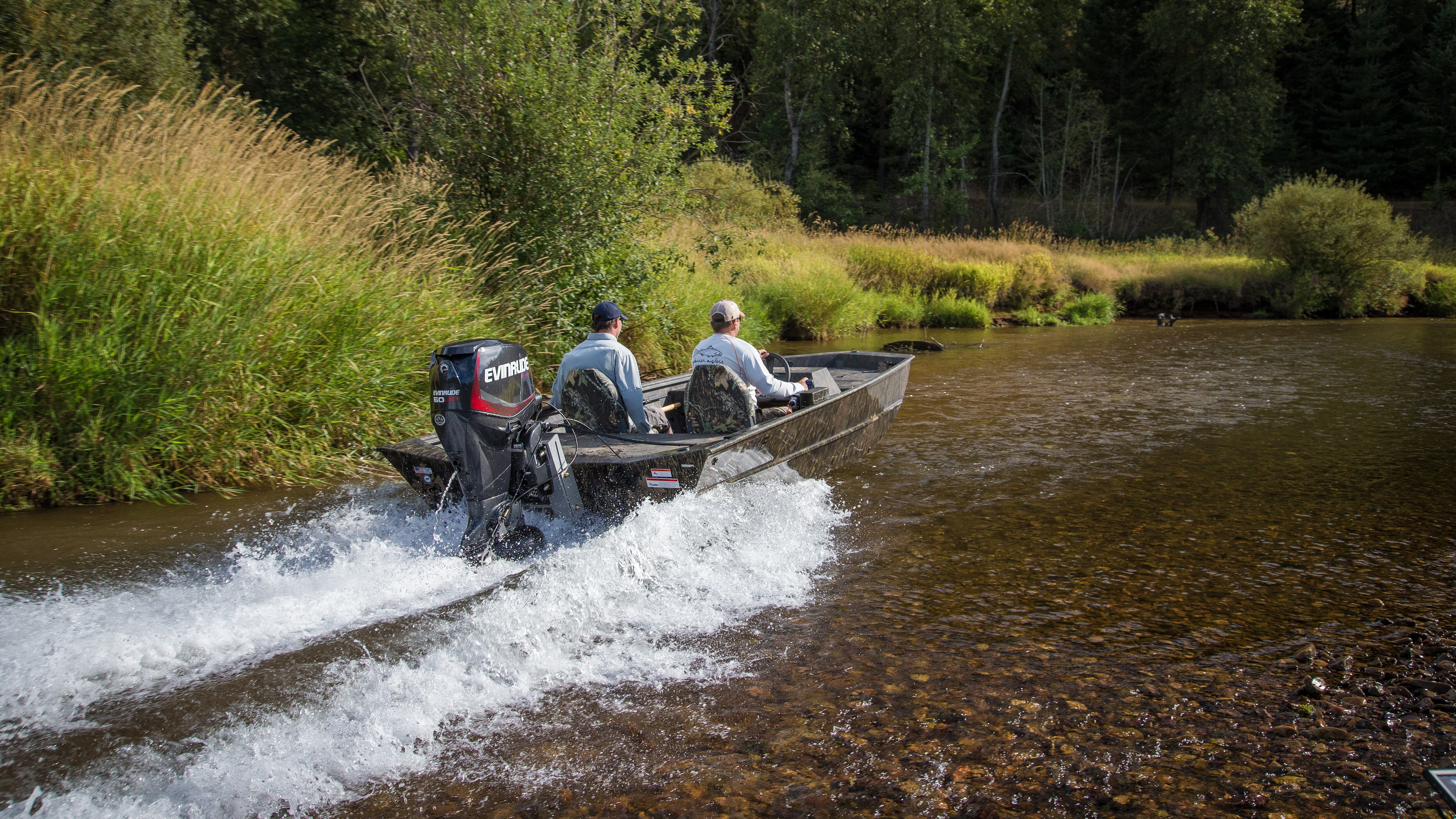 Two men driving a boat yielding a Jet series boat motor