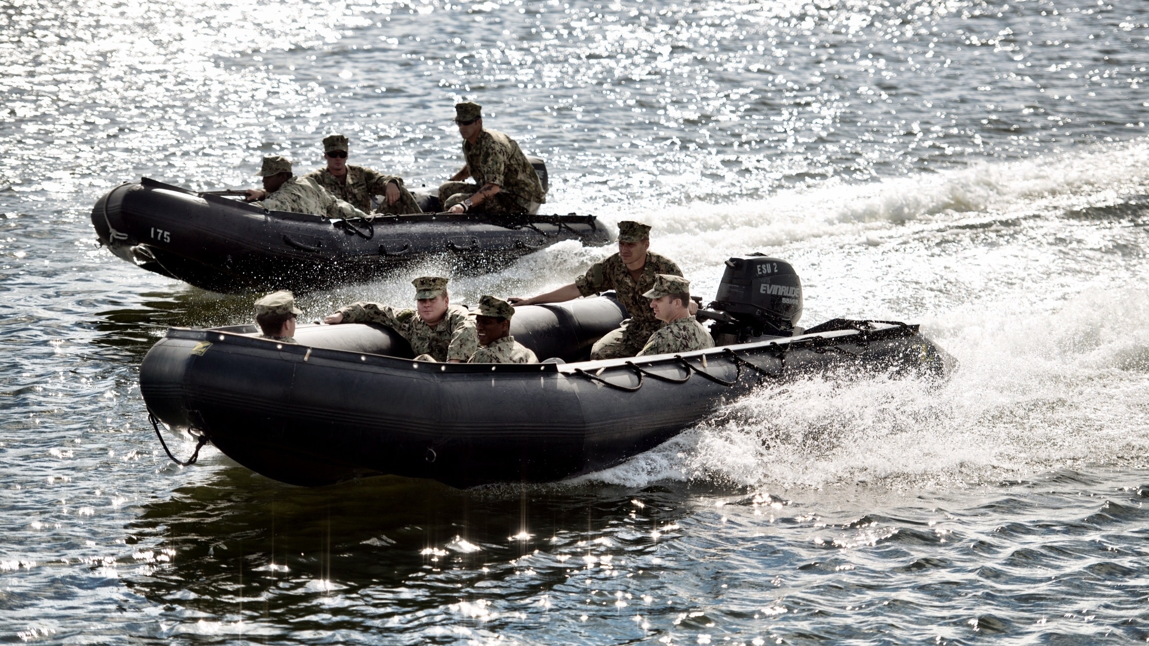 Military personnel driving boats yielding Evinrude motors