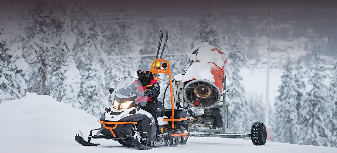 Man towing a snow cannon with his Lynx 69 Ranger 