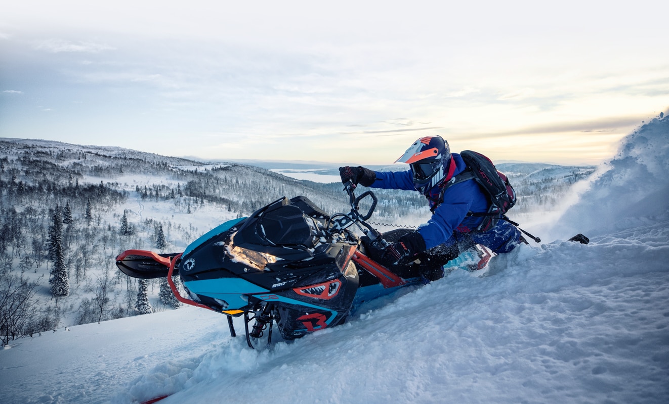 Muž prudce zatáčející svůj sněžný skútr Lynx BoonDocker 3900 na zasněženém kopci
