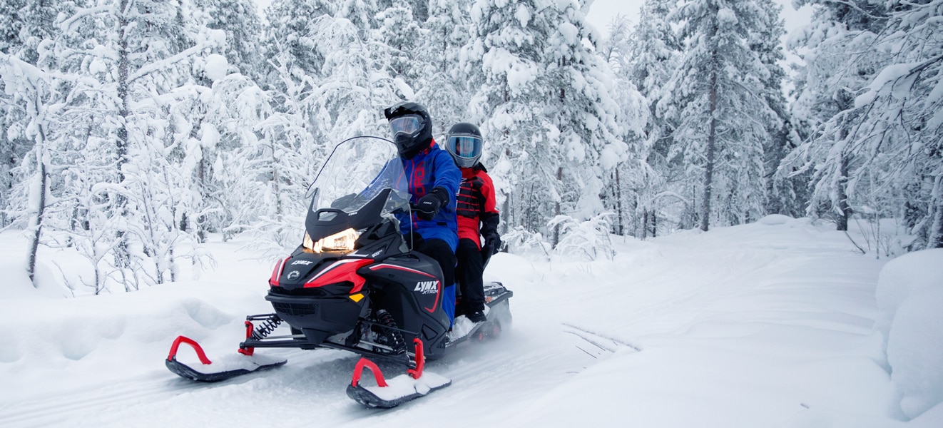  Par se vozi usred snježne šume na svom modelu motornih sanki Lynx Xtrim