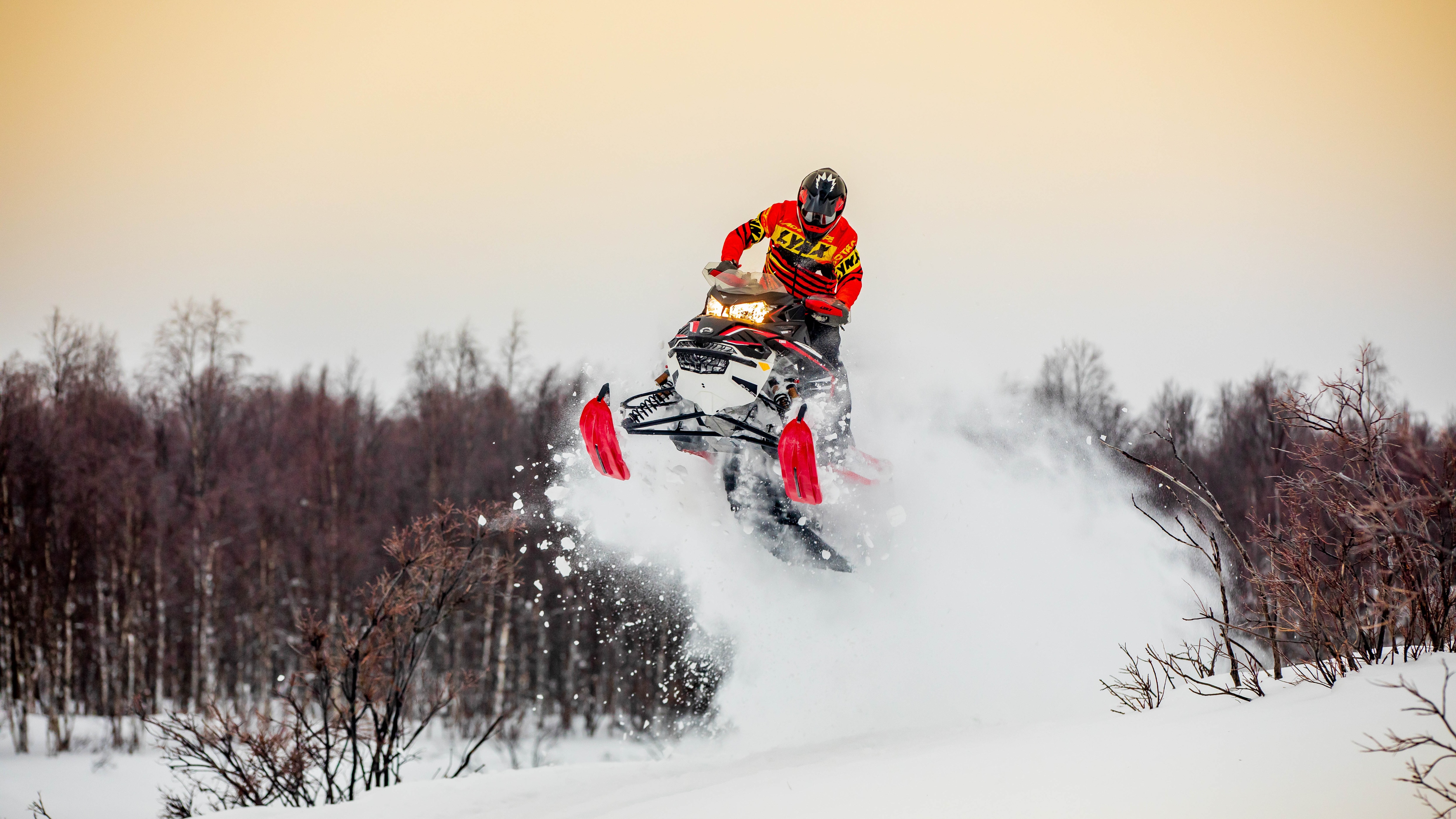 Muž skáče so svojim snežným skútrom 2021 Lynx Rave.