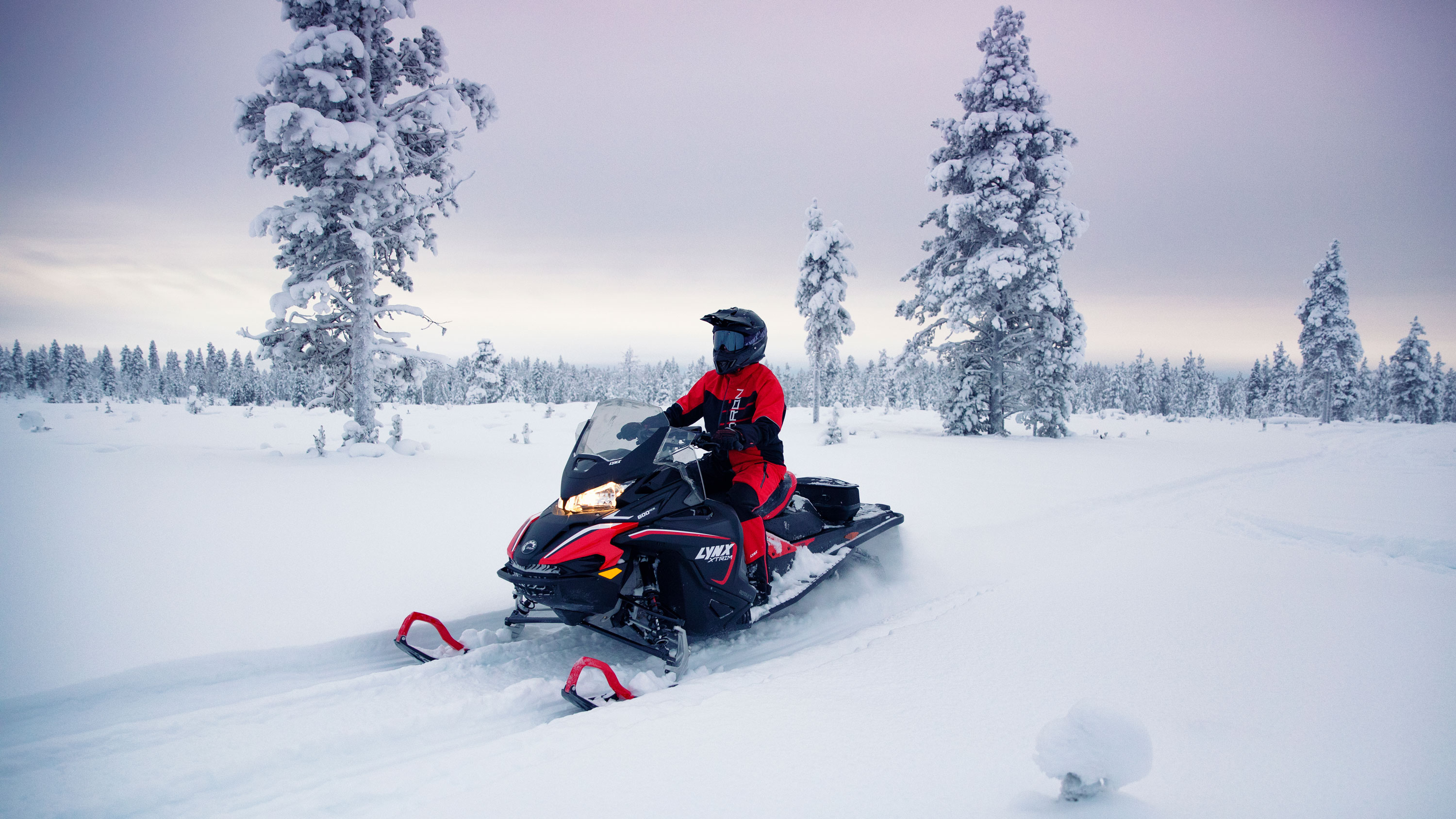 A man is driving his 2021 Lynx Xtrim Model on a snowy road