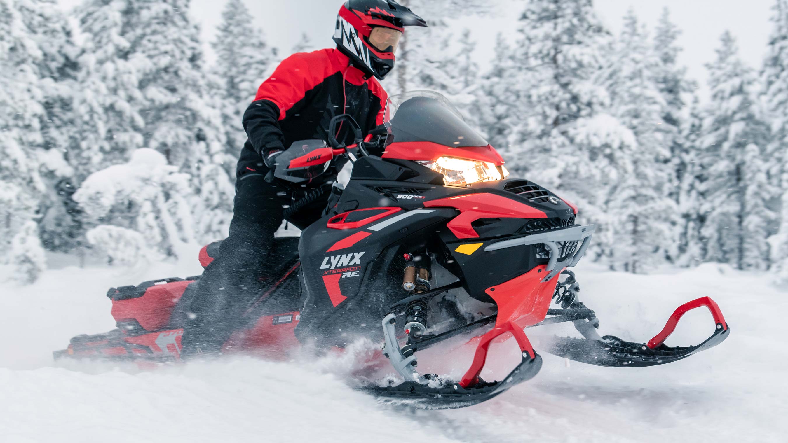 Lynx Xterrain RE in motoslitta in mezzo la foresta innevata