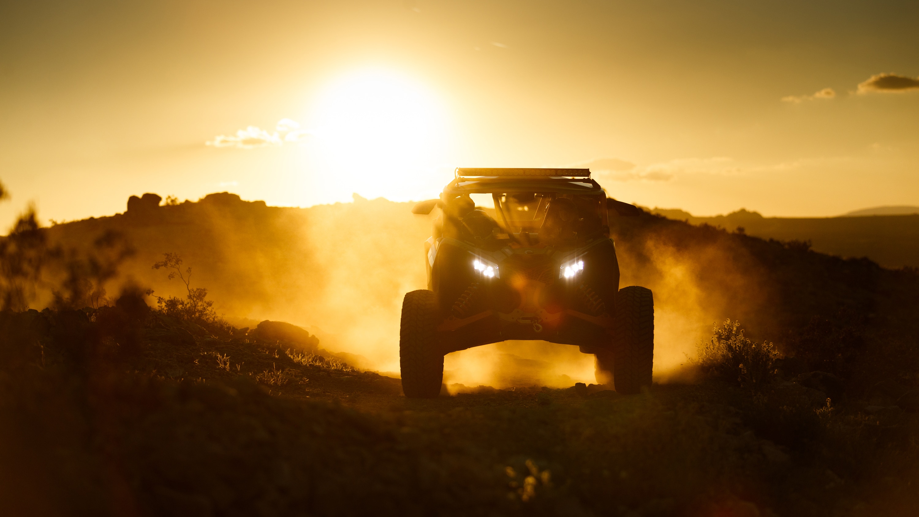 Maverick driving down a cliff with the sunset behind