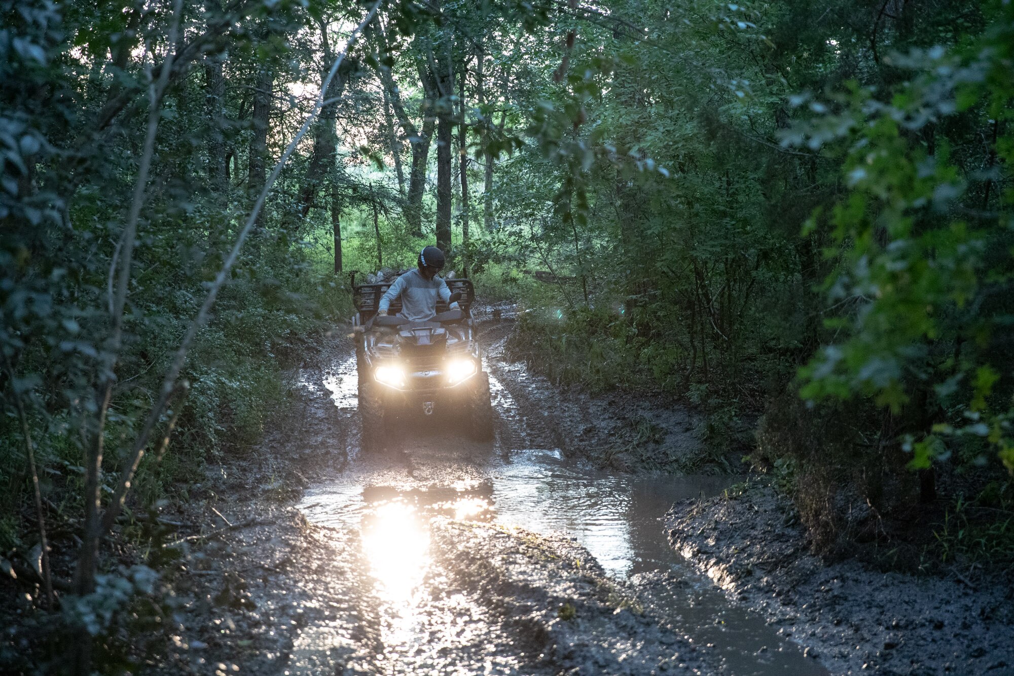 Muž jedoucí na čtyřkolce Outlander bahnitou cestou