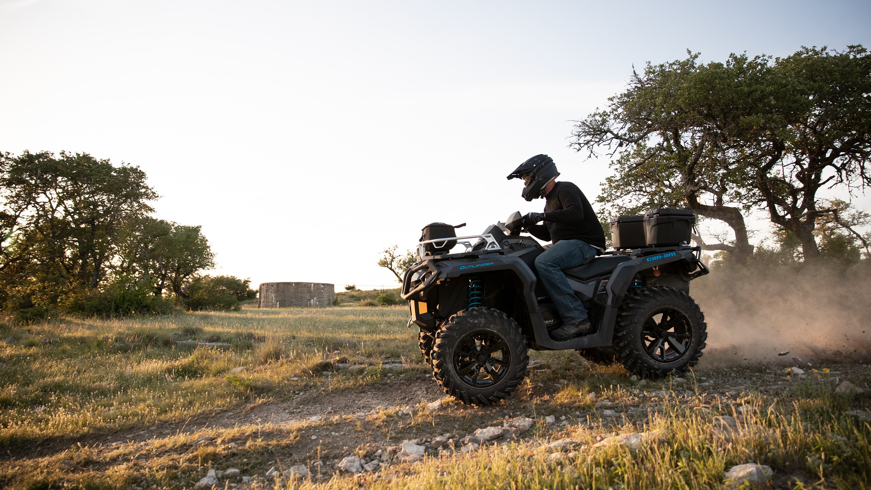 Muž jedoucí otevřenou krajinou na čtyřkolce Outlander ATV