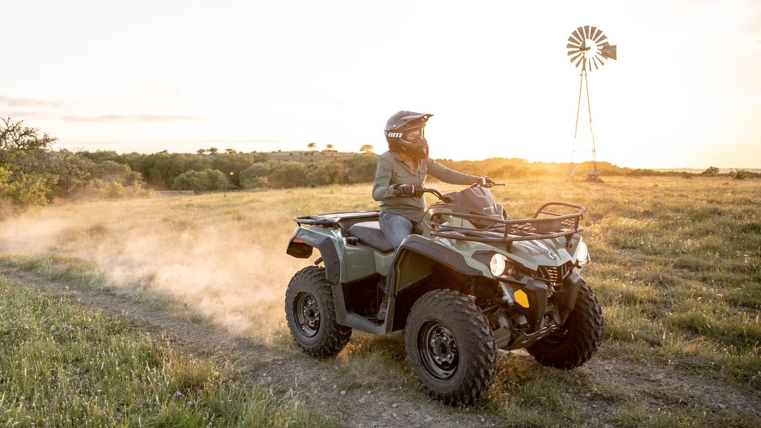 Woman driving an Outlander 450-570 through an open field