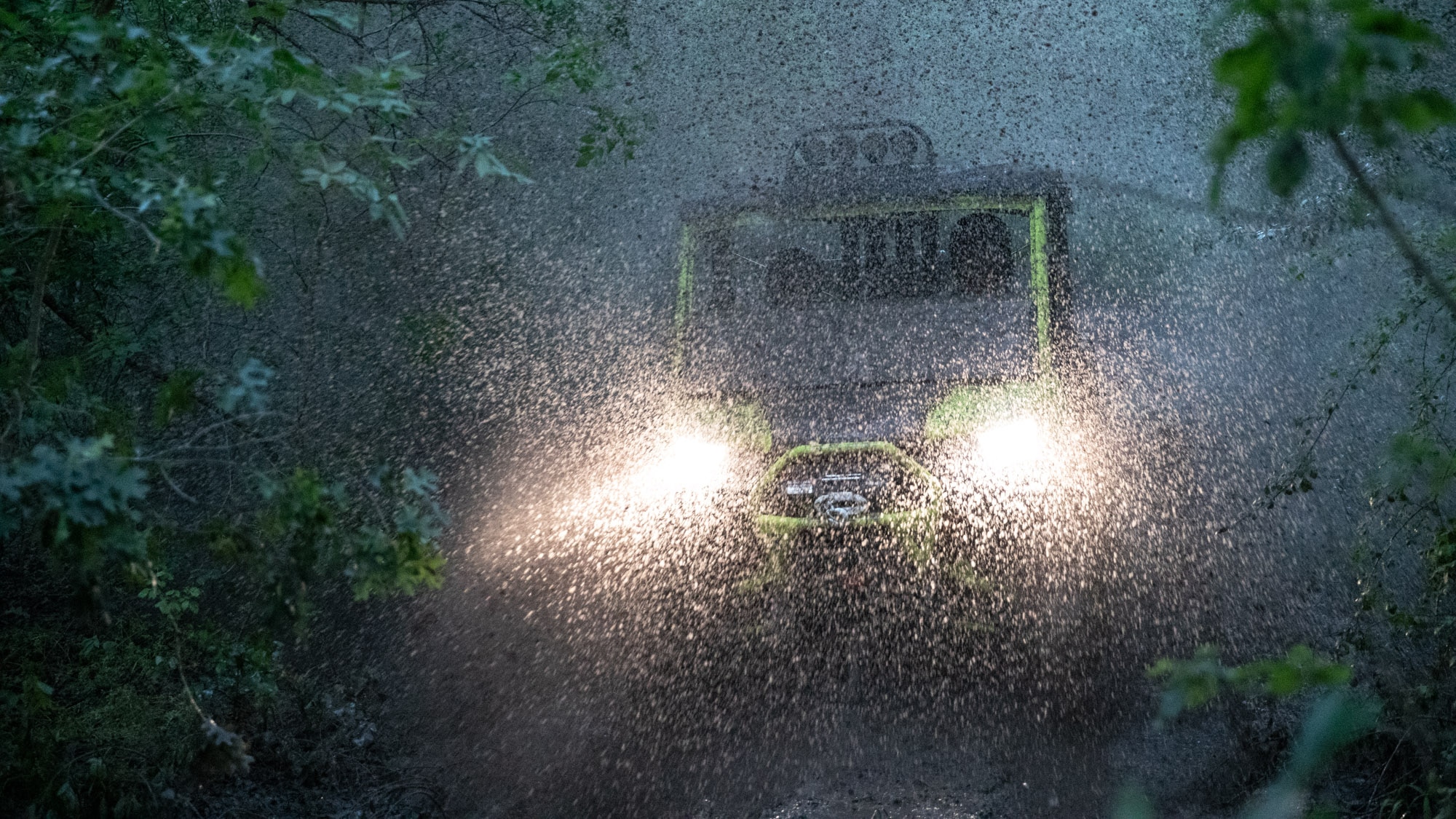 Muži jedoucí v lijáku na čtyřkolce SSV Traxter 