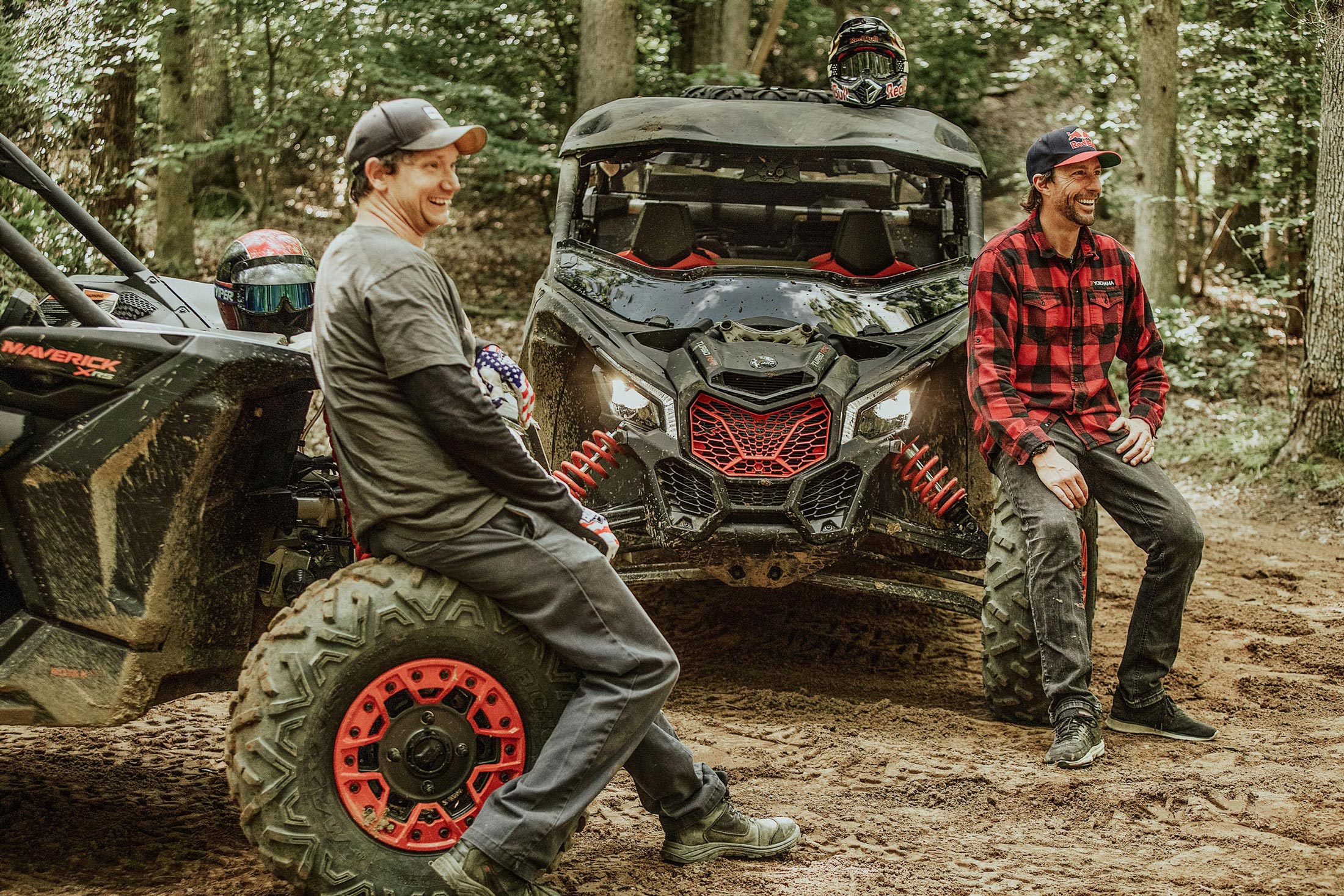 Travis Pastrana s kamarátom sa smejú a opierajú o svoje vozidlá Maverick RS