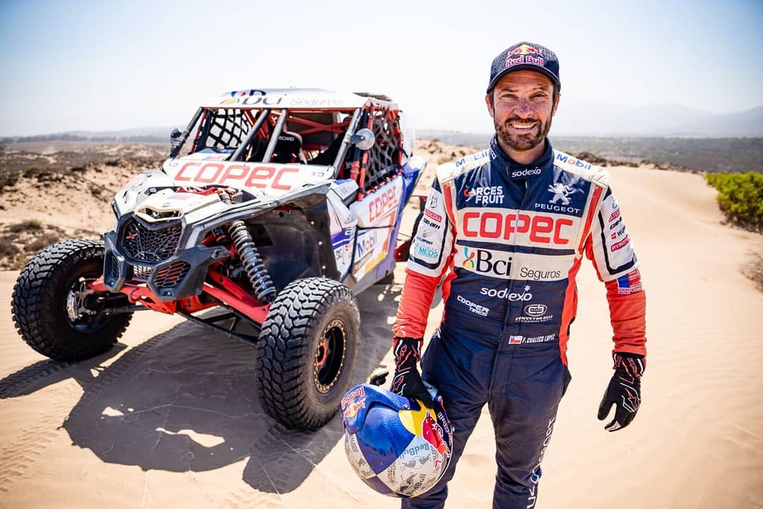 Man driving a Maverick X3 in desert dunes