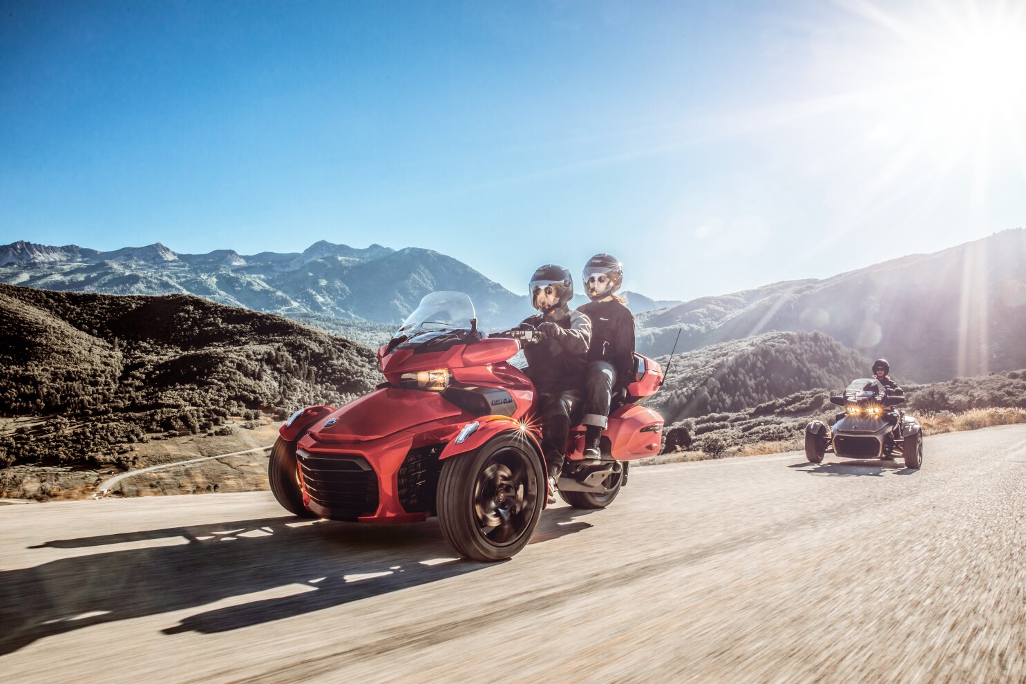 A couple driving a Spyder F3 next to their friend