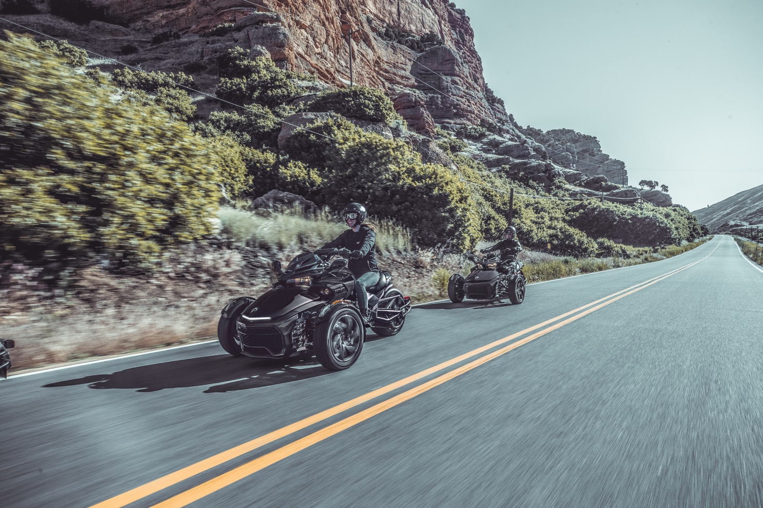 Woman and man driving their Ryker down a road