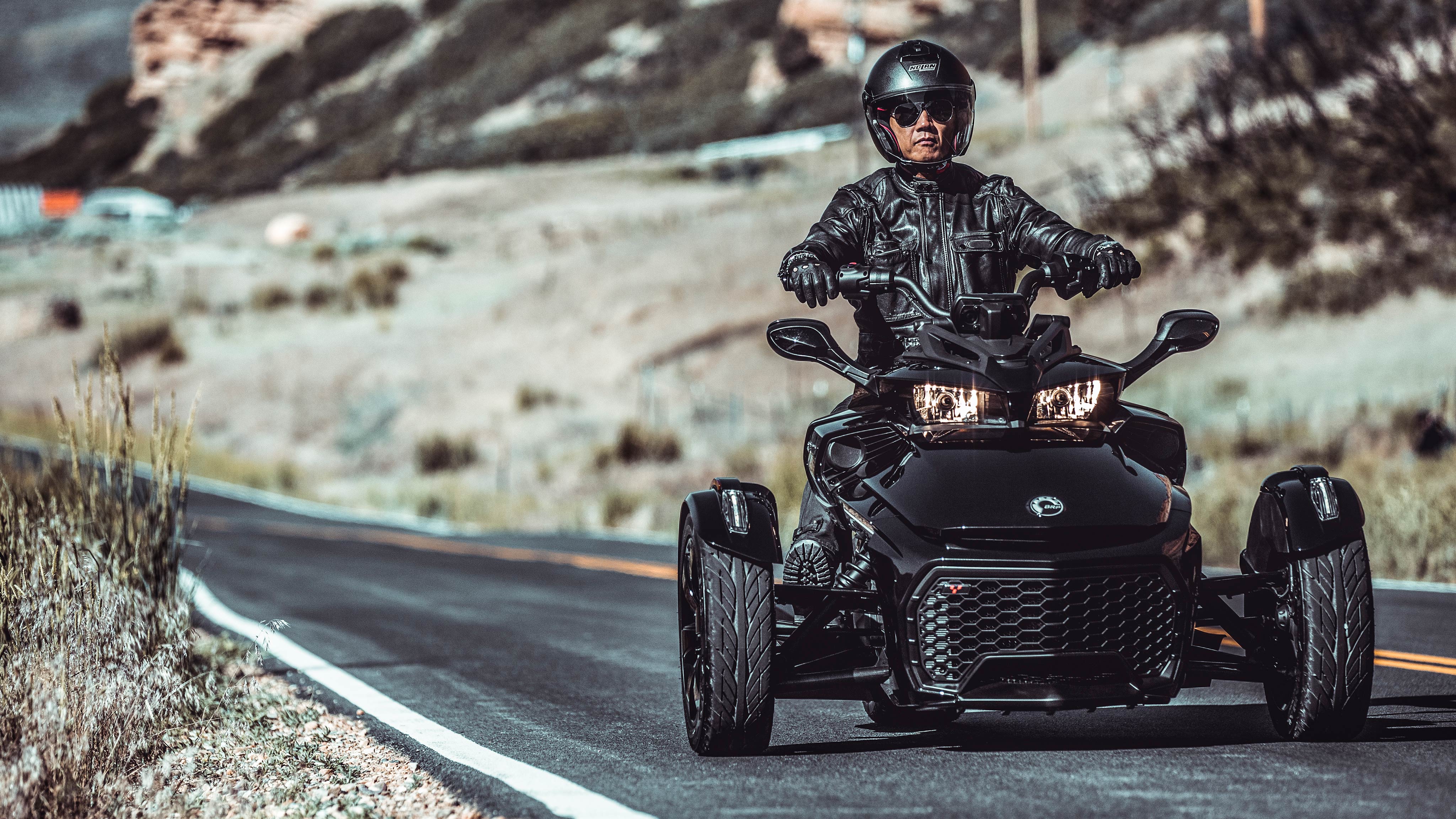 A man driving his Spyder F3 on a road