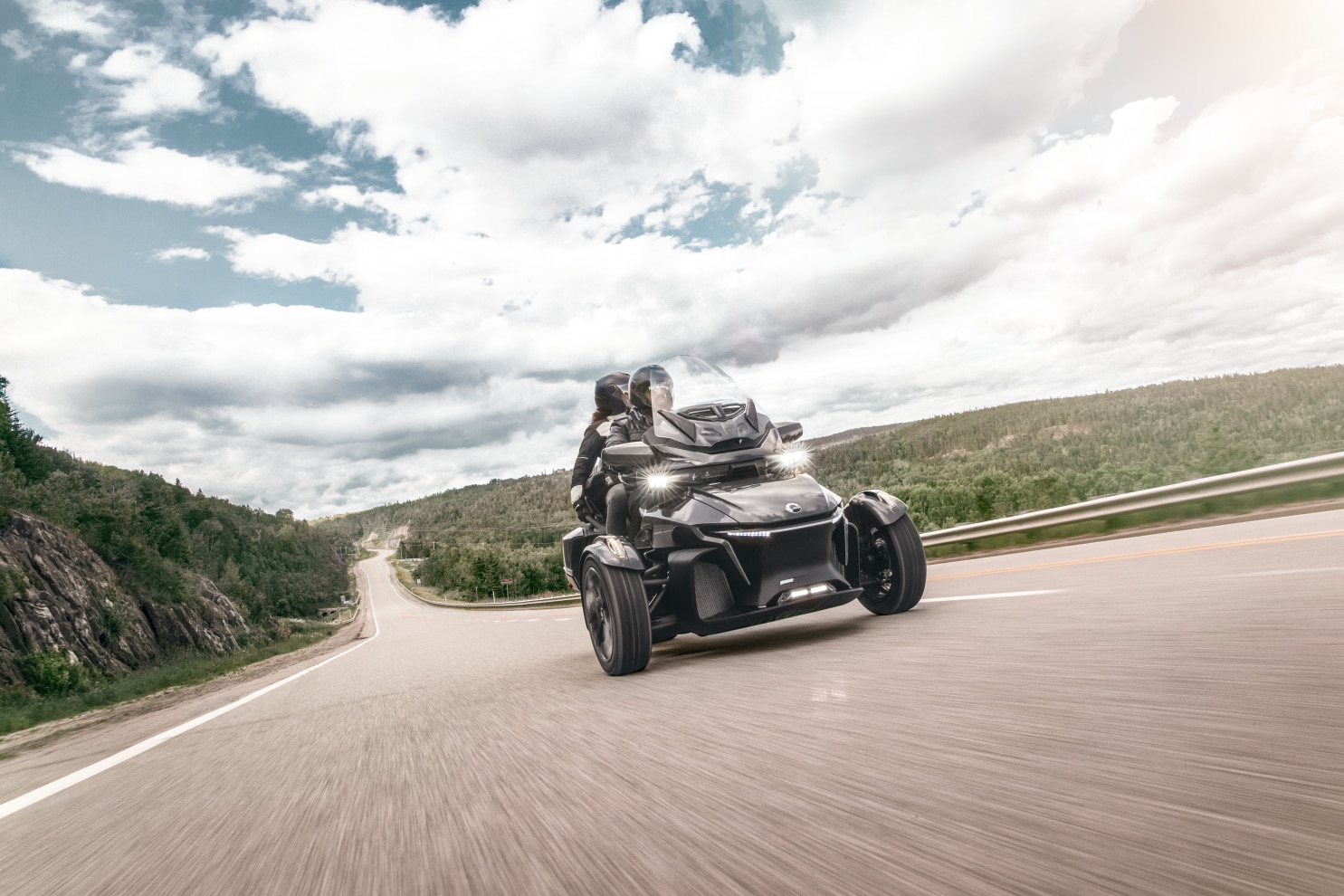 A couple ride their Spyder RT on the road