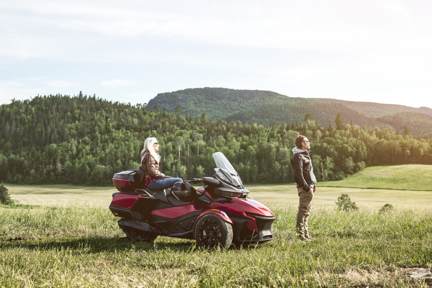 A couple near their Spyder RT in an open field