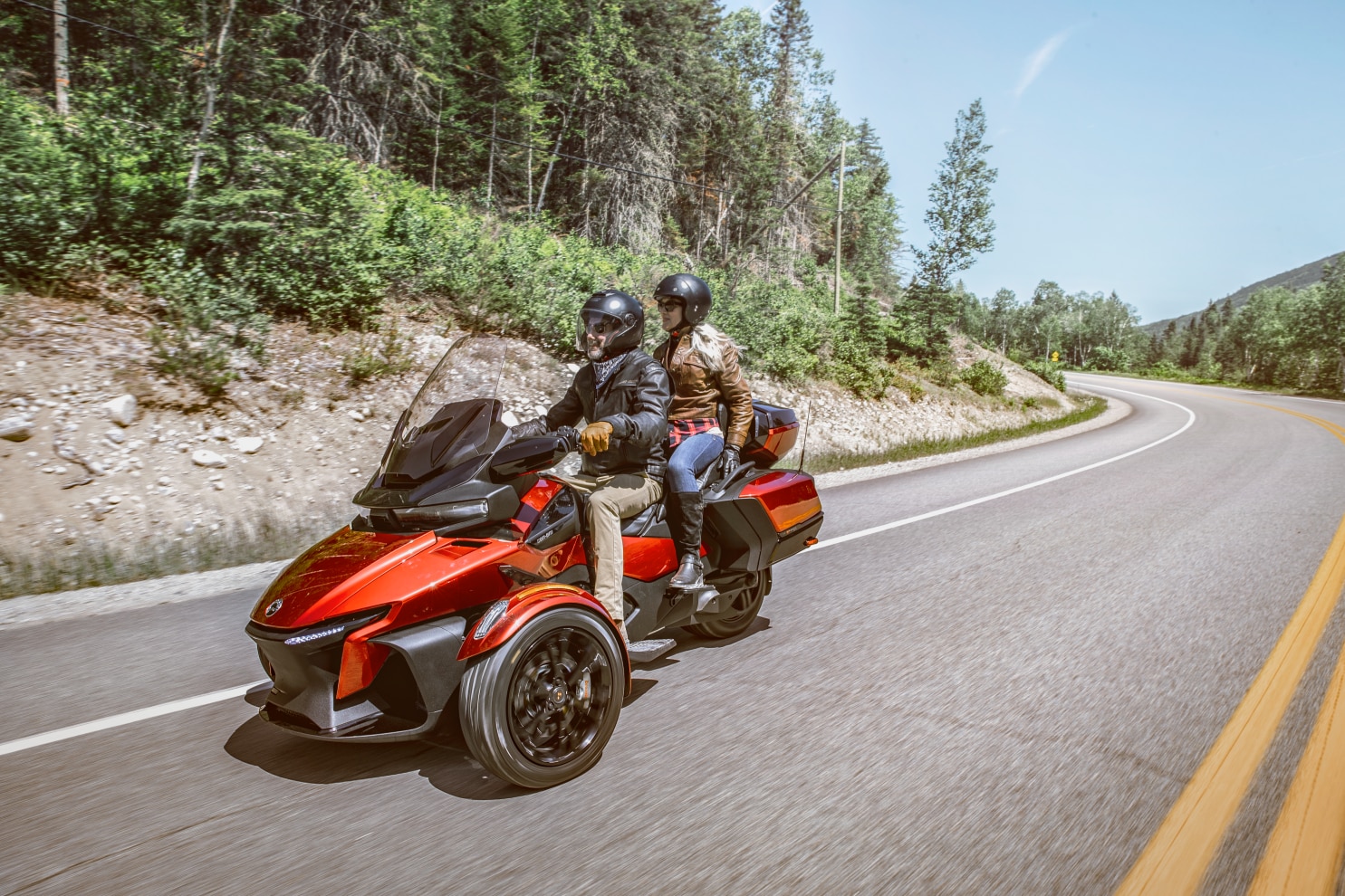  Pogled pod pravim kutom para koji vozi Can-Am Spyder RT slikovitom cestom