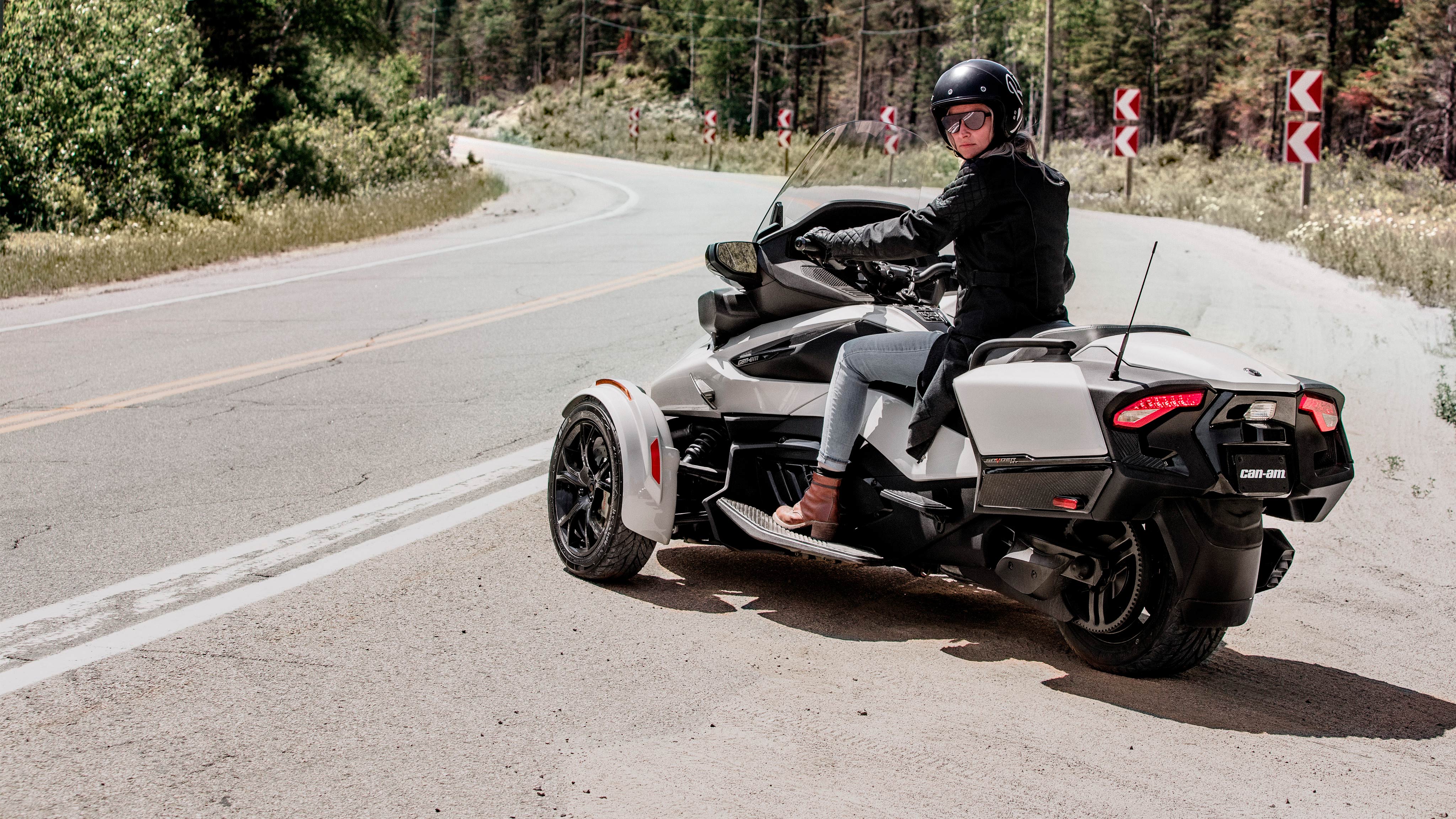 Une femme conduit un véhicule blanc nacré Can-Am Spyder RT