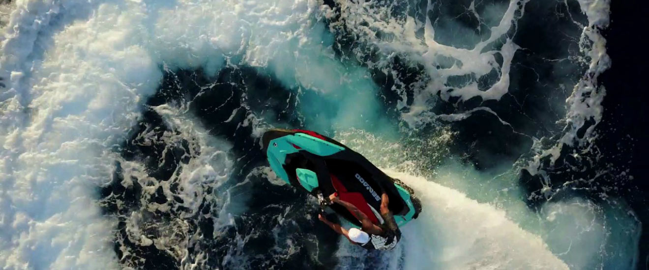 Vogelansicht eines Mannes, der sein persönliches Wasserfahrzeug Sea-doo in den Wellen reitet
