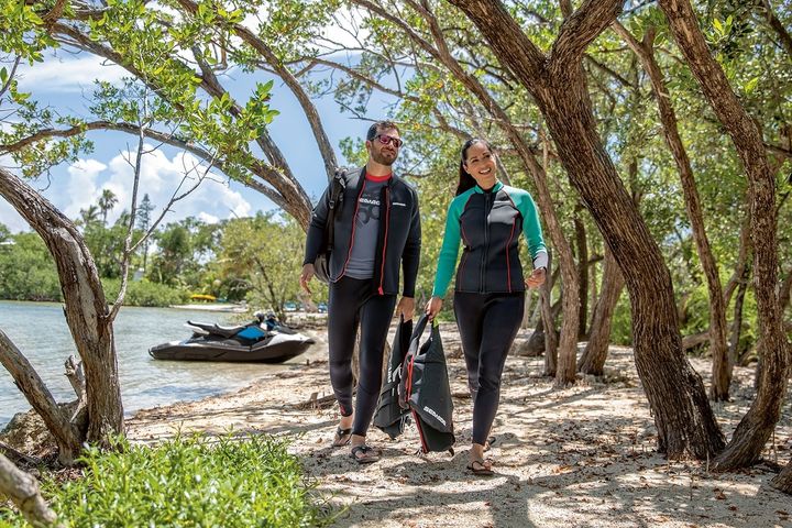 Homme et femme marchant en vert après une balade en Sea-Doo